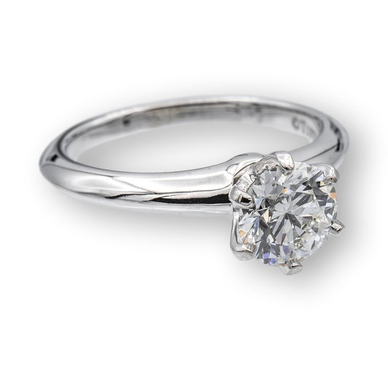 Tiffany & Co. Diamond Engagement ring finely crafted in a six prong platinum mounting featuring a 1.05 ct round brilliant diamond center graded F color and VS2 Clarity. The diamond is inscribed with Tiffanys serial numbers and is graded  Excellent