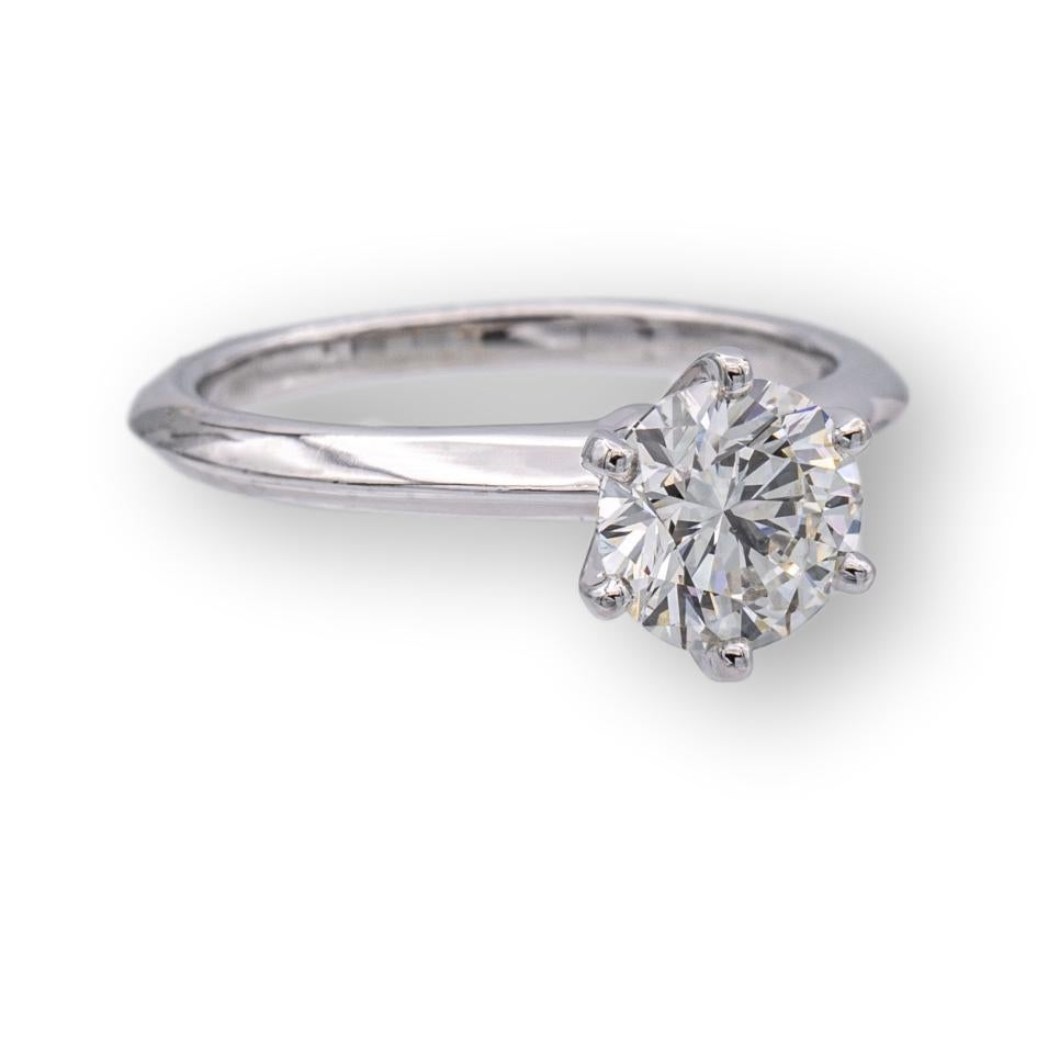 Tiffany & Co. Diamond Engagement ring finely crafted in a six prong platinum mounting featuring a 1.19 ct round brilliant cut diamond center graded I color and VS1 Clarity. The diamond is inscribed with Tiffanys serial numbers and is graded