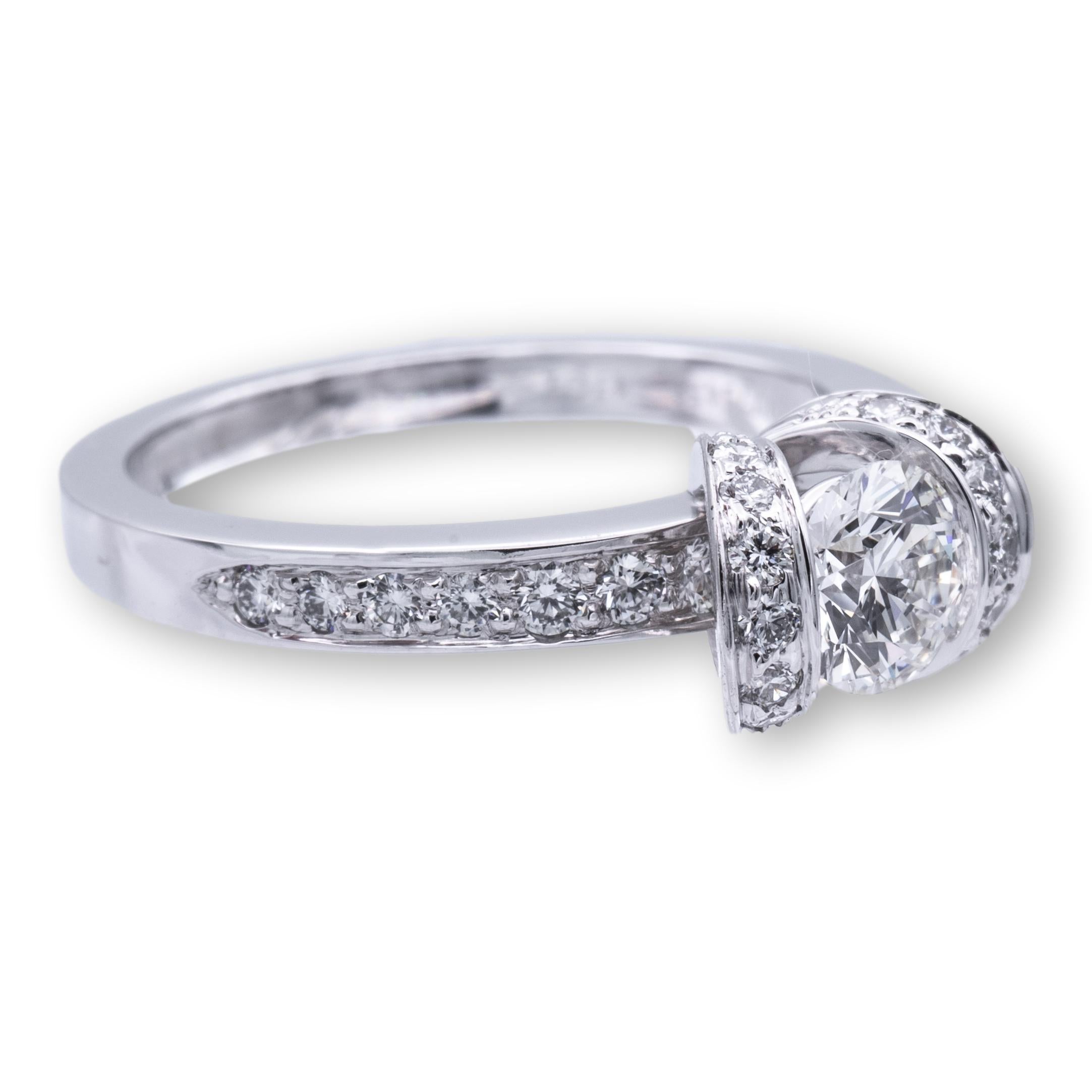 Tiffany & Co. Ribbon engagement ring finely crafted in platinum with a 0.47 ct round brilliant cut center diamond G color VVS2 clarity. The ring has channel set diamonds on each side weighing 0.36 carats total weight approximately. The center