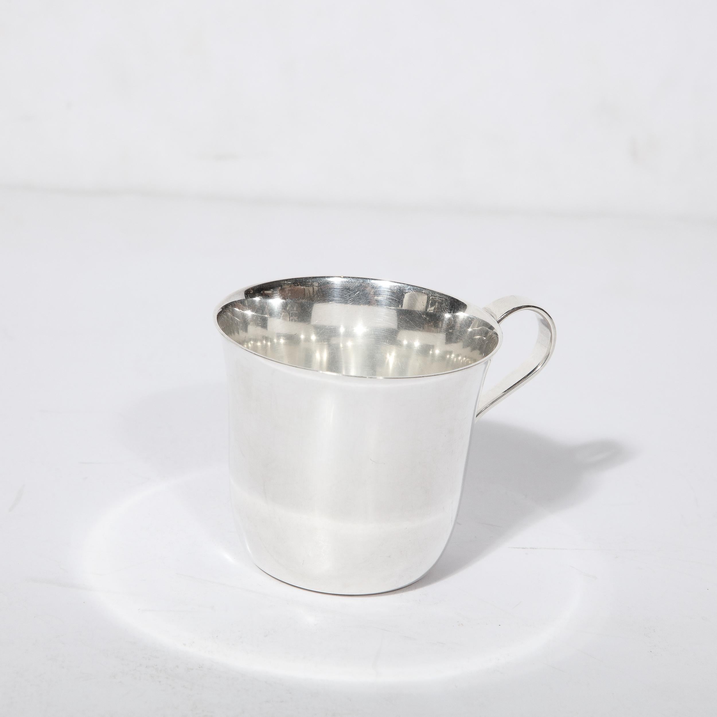This lovely Tiffany and Co. Sterling Silver Handled Cup originates from the United States during the 20th Century. Featuring a minimalist construction in beautiful proportions, the piece is rendered in sterling silver and beautifully polished. With