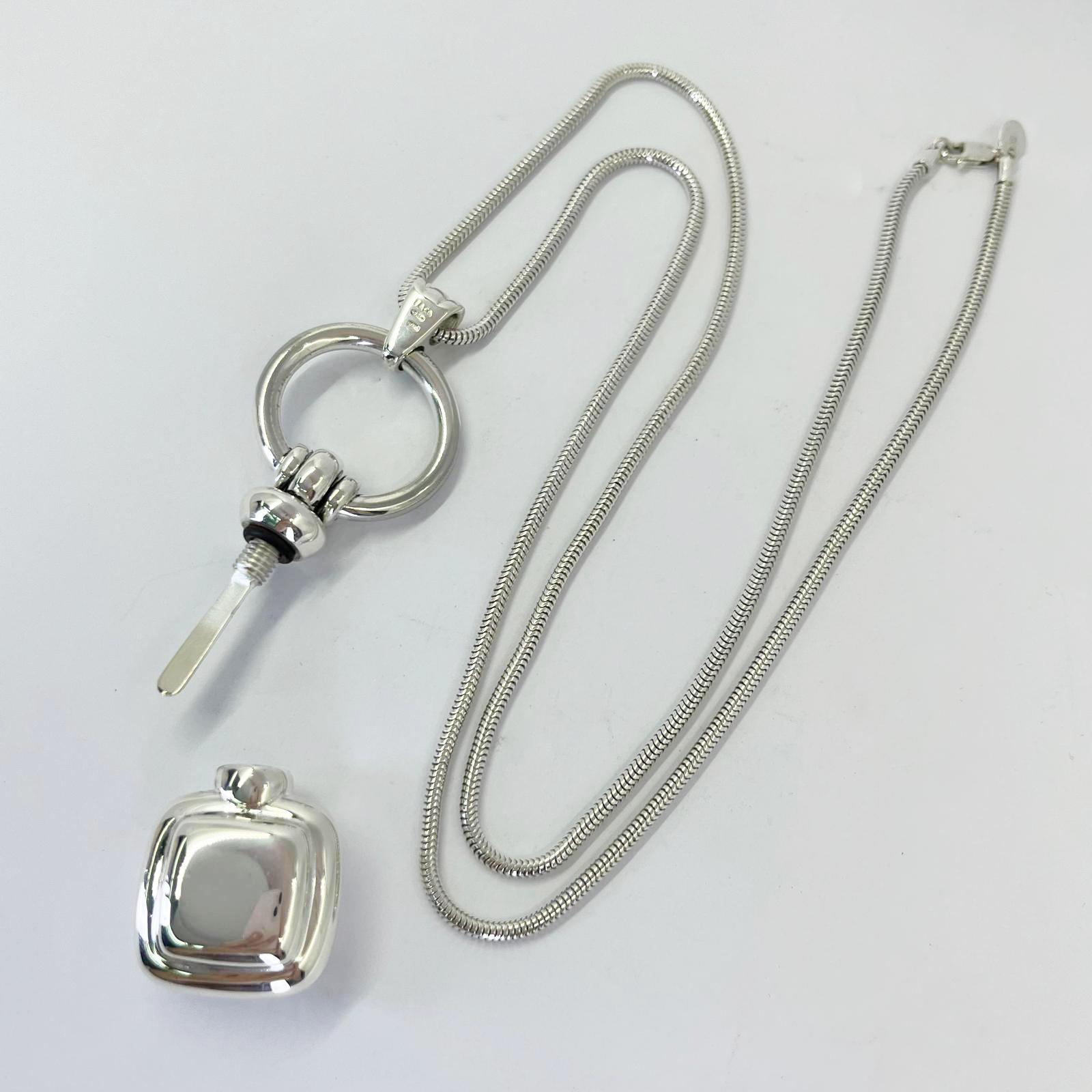 Tiffany and Co. sterling silver perfume bottle pendant on snake chain necklace measuring 28 inches long with lobster clasp. Opens to reveal applicator inside. $1,000 MSRP. Includes Tiffany box or pouch.