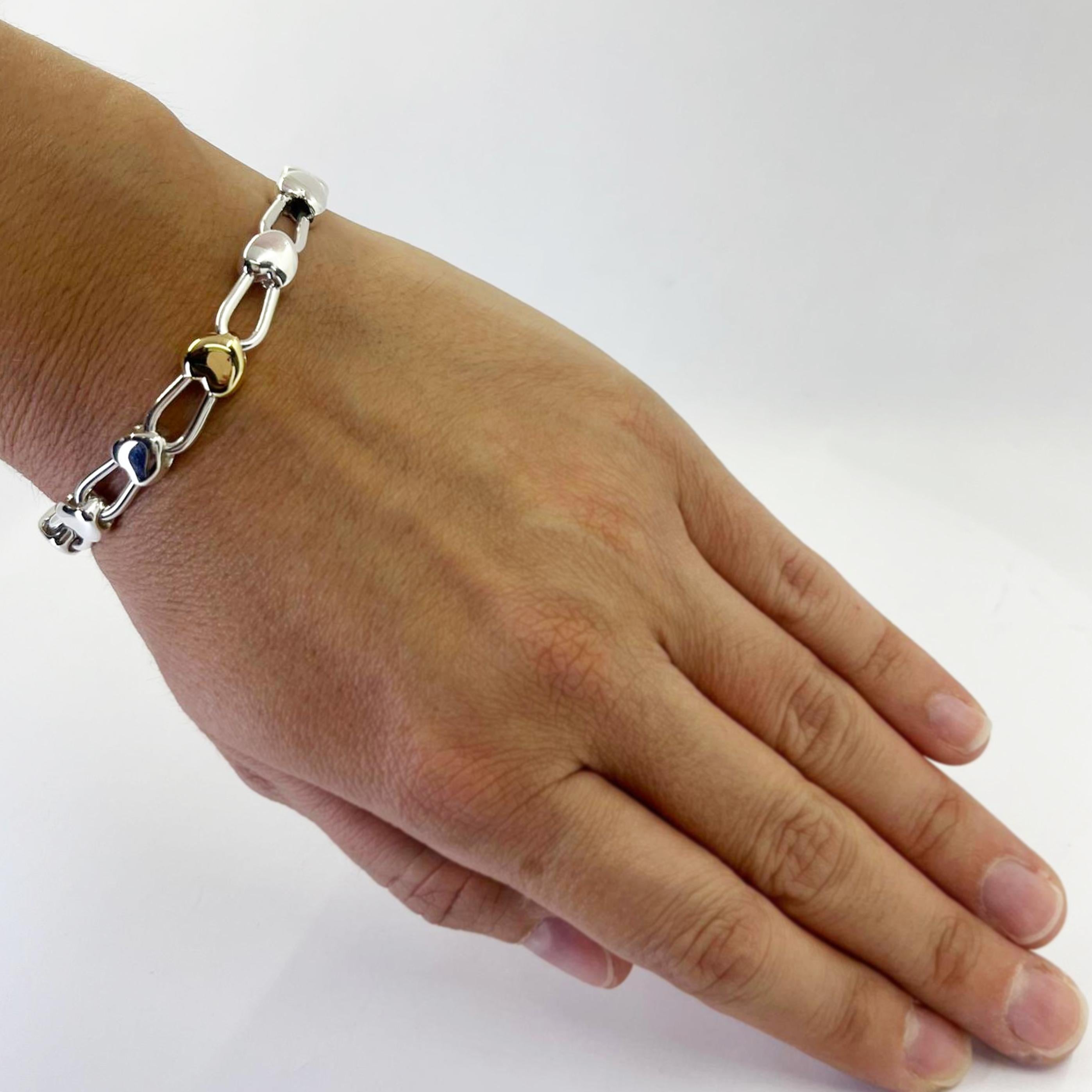 Tiffany and Co. sterling silver heart bracelet with 18 karat yellow gold accent. 7.25 inches long with lobster clasp. $1,500 MSRP. Includes Tiffany travel pouch.