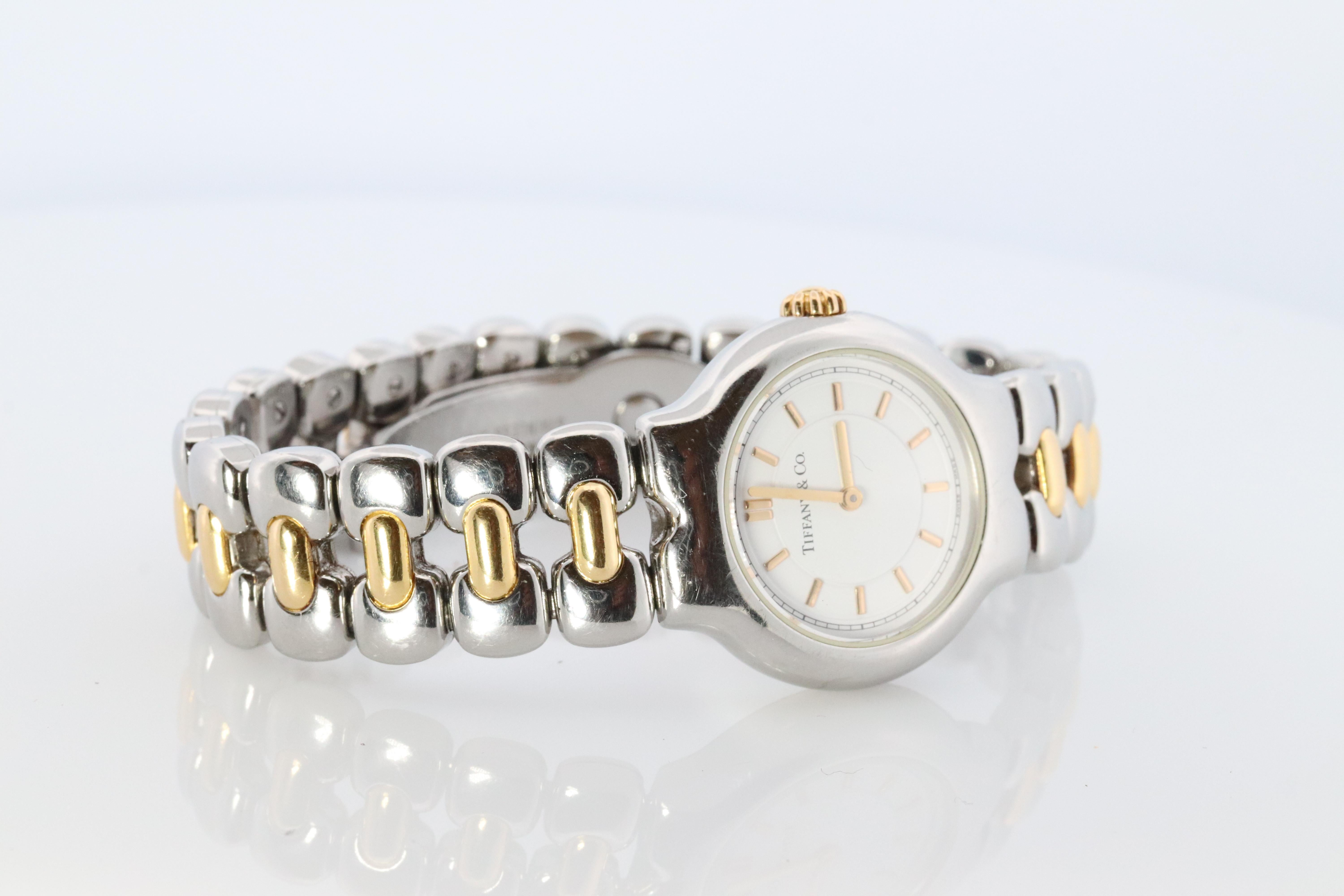 RARE Tiffany und Co Tessoro Uhr
L0112

18k Gold mit Edelstahl
25mm Gehäuse

Schöne Uhr. Quarz. Funktioniert und hält die Zeit. Neue Batterie installiert.

Kommt mit original Tiffany Watch Box.

Zustand: Geringe sichtbare Gebrauchsspuren.

7 Zoll