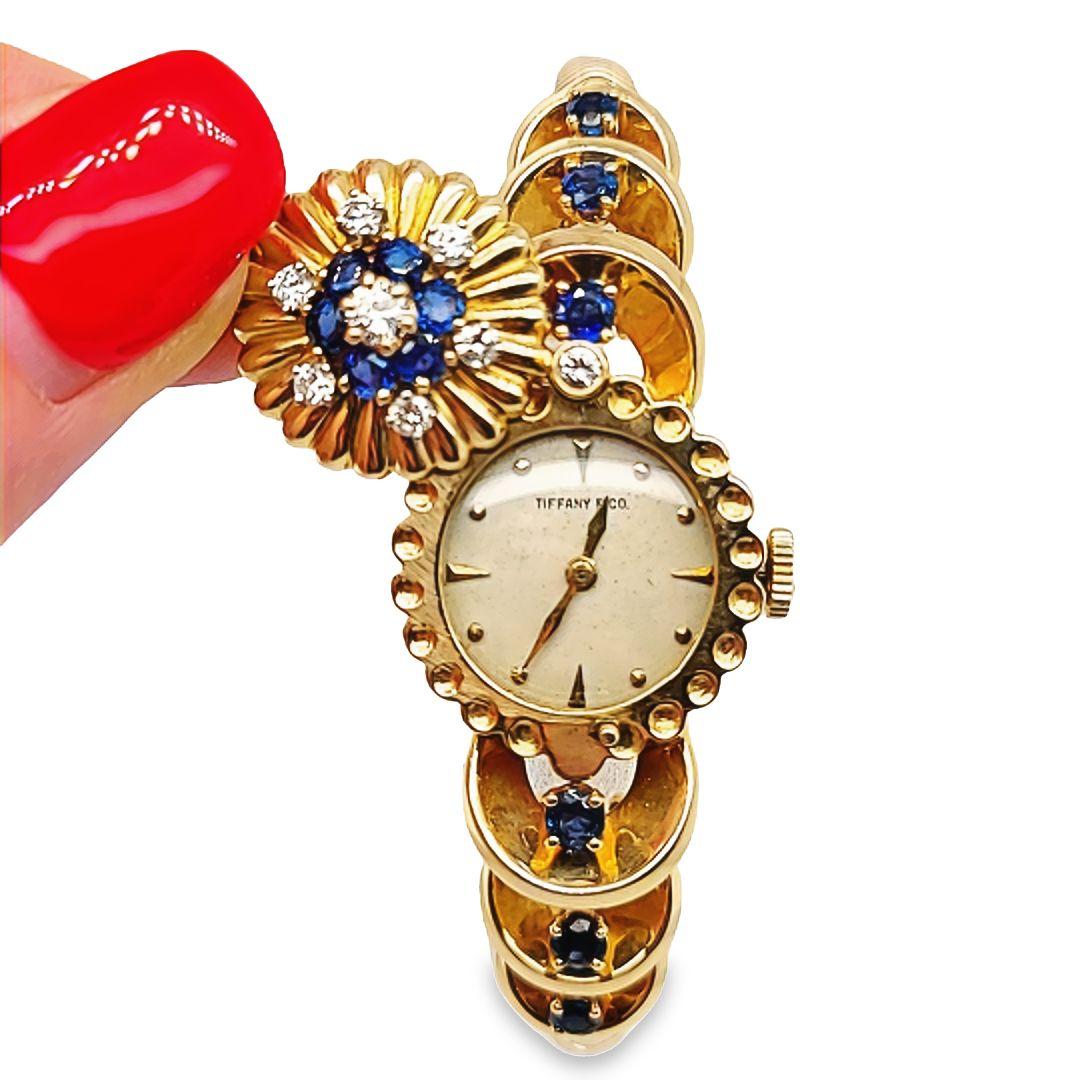 Rare Tiffany and Co 14 Karat Yellow Gold Hidden Watch Bracelet Featuring A Hamilton 17 Jewel Manual Wind Movement. Cover Swivels over Dial. 12 Round Sapphires Total Approximately 1.00 Carat Accented By 9 Round Brilliant Cut Diamonds of VS Clarity