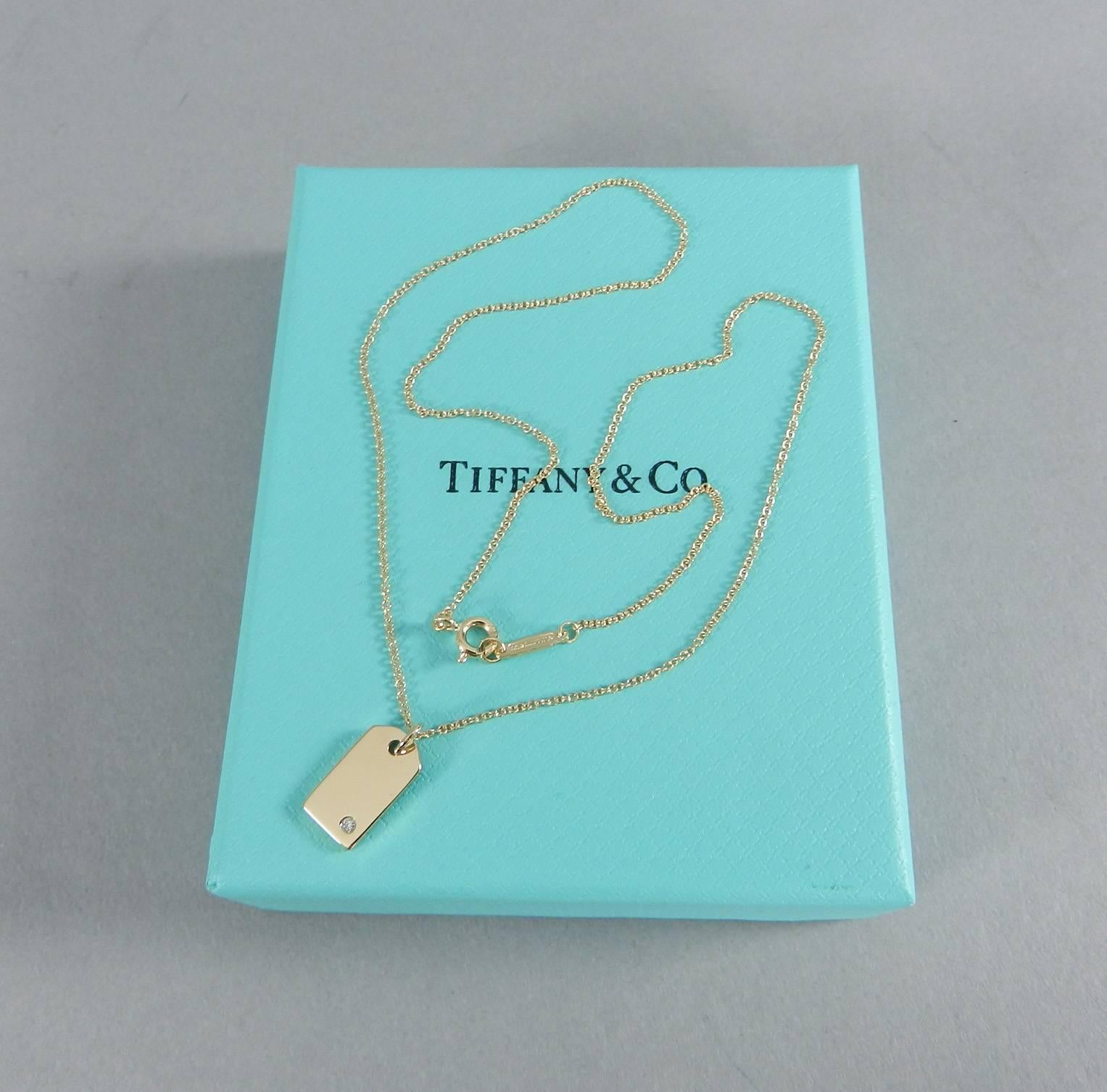 Tiffany and Co 18k Yellow Gold Mini Tag Charm Diamond Pendant Necklace.  Brand new without tags. Received as a gift and unworn.  Includes box, pouch, presentation card. Necklace chain is 16