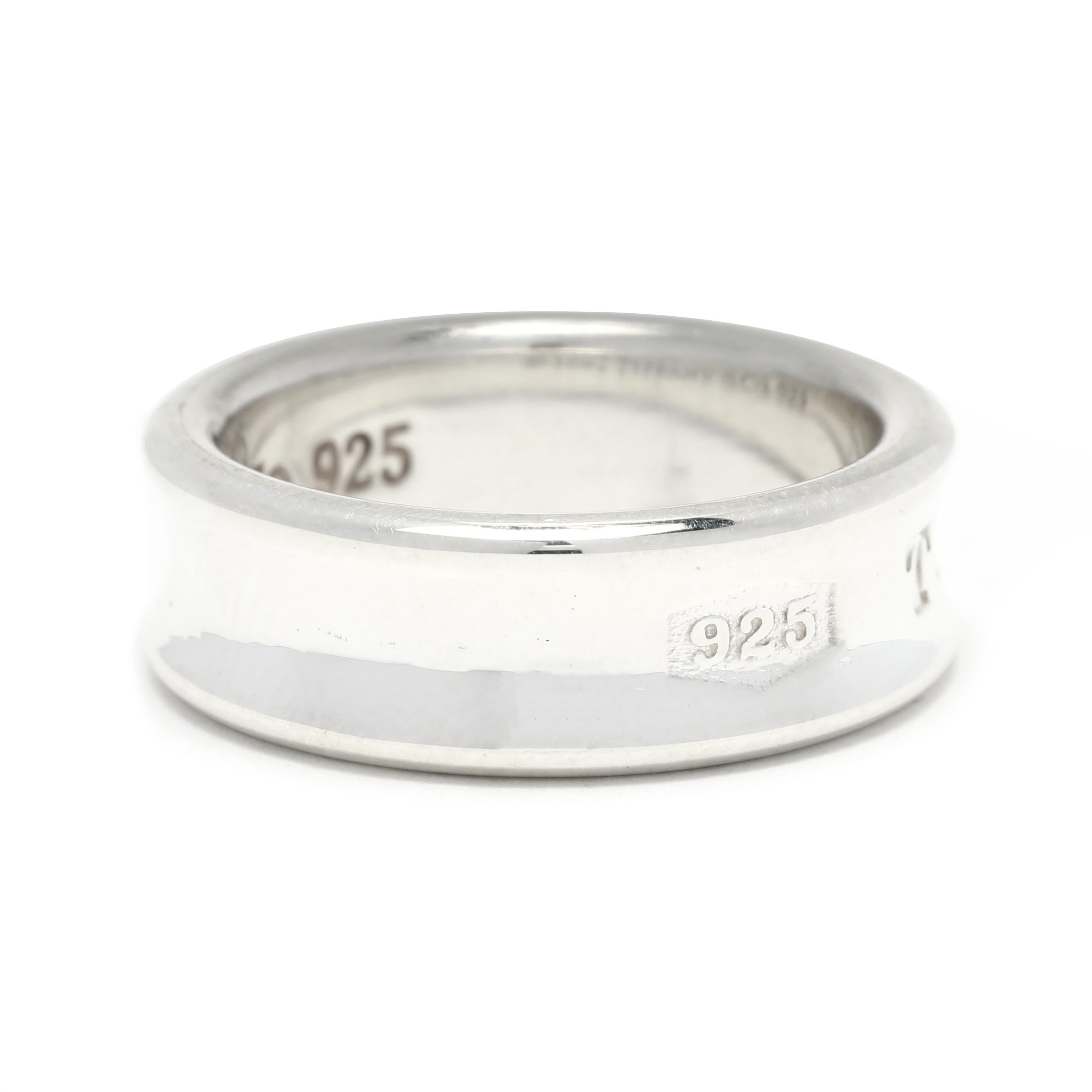 This gorgeous sterling silver Tiffany & Co. 1837 wide band ring is a timeless classic. Crafted in sterling silver with a sleek, polished finish, this ring features the iconic 1837 engraving, a tribute to the company's founding year. The wide band is