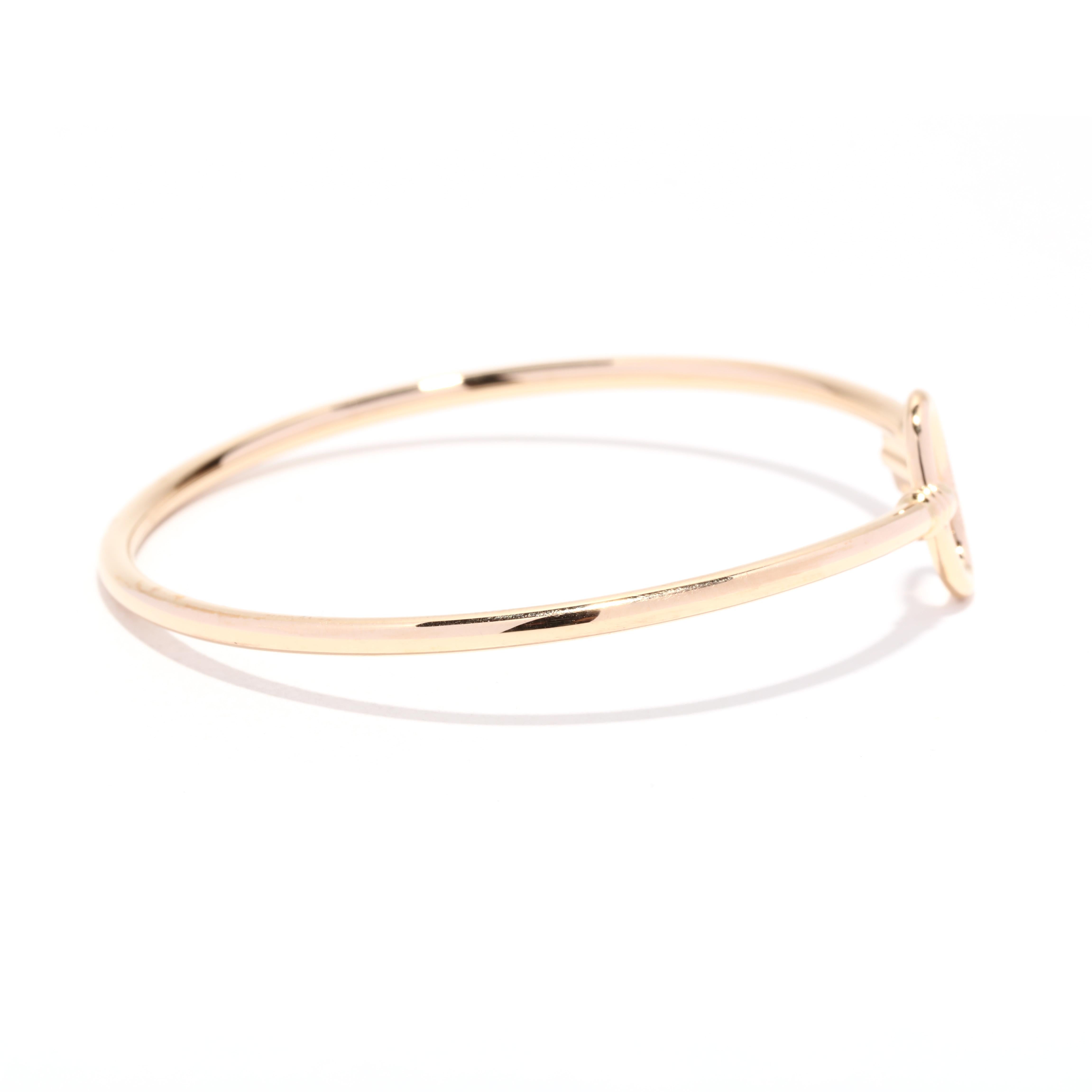 A Tiffany & Company 18 karat gold key wire cuff bracelet. This stackable cuff features a thin flexible design with an open oval at one end and a key motif at the other.

Length: 7 in. 

Width: 1/2 in.

Weight: 4.6 dwts. / 7.2 grams

Stamps: T&CO