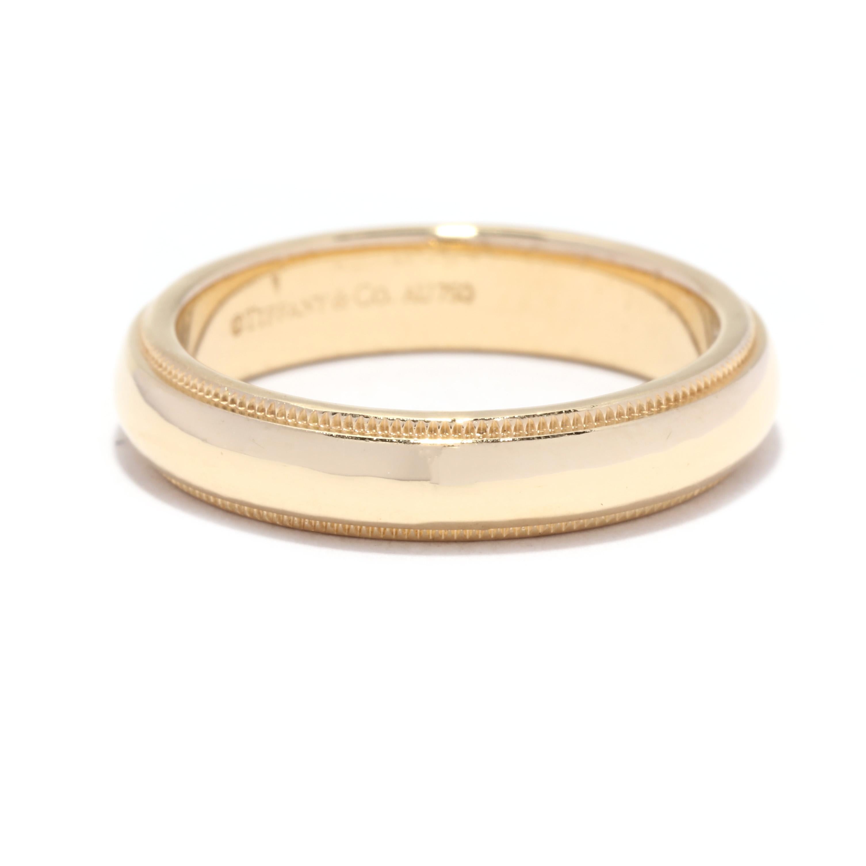 A vintage Tiffany & Co 18 karat yellow gold milgrain wedding band. This stackable band features a slightly domed design with a polished center and with milgrain detailing in an eternity design.

Ring Sise 6.25

Width: 4.25 mm

Weight: 4.2 dwts. /