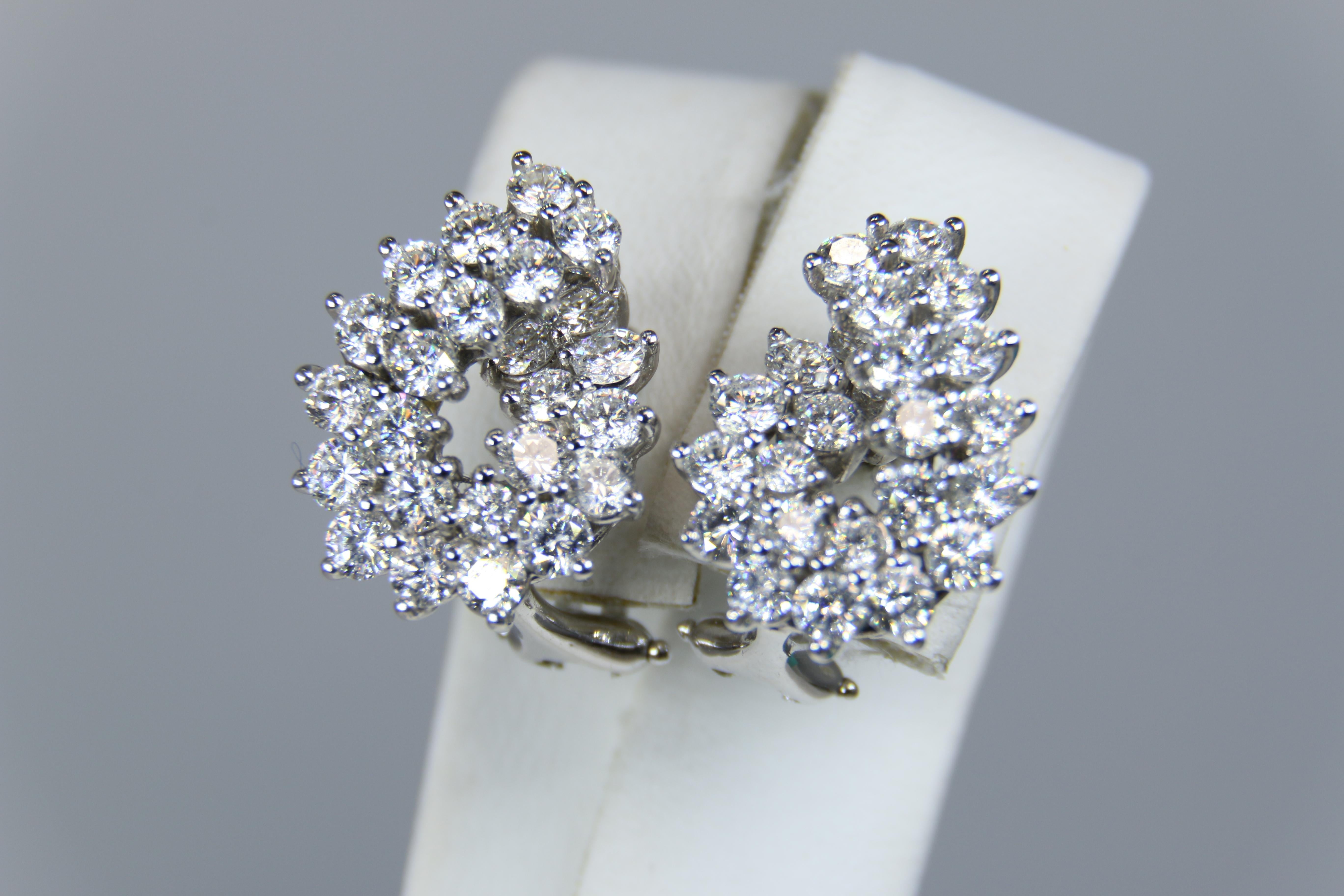 Tiffany & Co Platinum Diamond Earrings have a double row swirl pattern prong set with a total of 4.16 carats of bright round brilliant cut diamonds. Earrings feature an Omega style clip on each with pad area for security. These clip style are easily