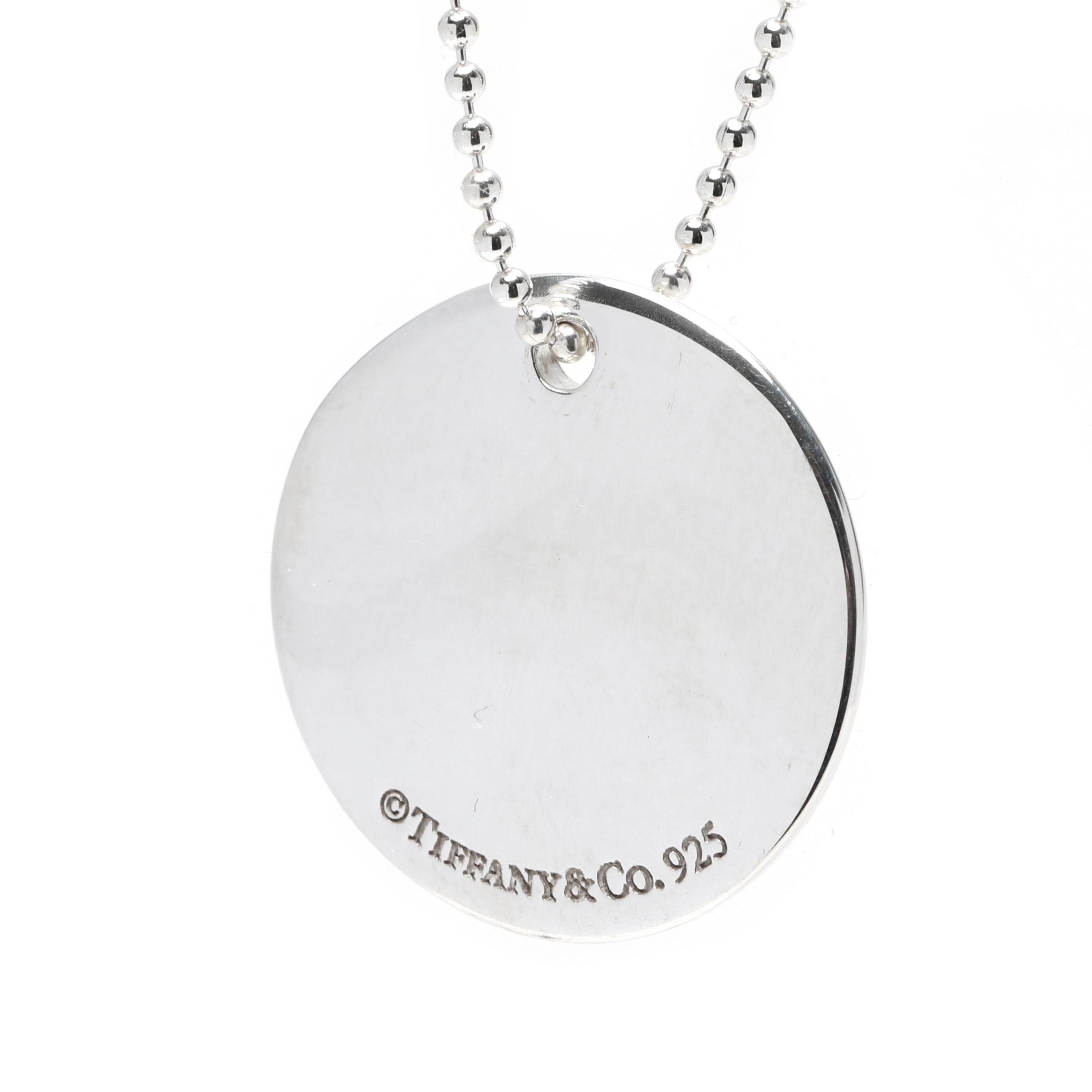 This classic Tiffany and Company script A initial necklace is the perfect way to add a personalized touch to any look. Crafted in sterling silver, this simple disc pendant features a script A initial and hangs from an 18-inch chain. This timeless