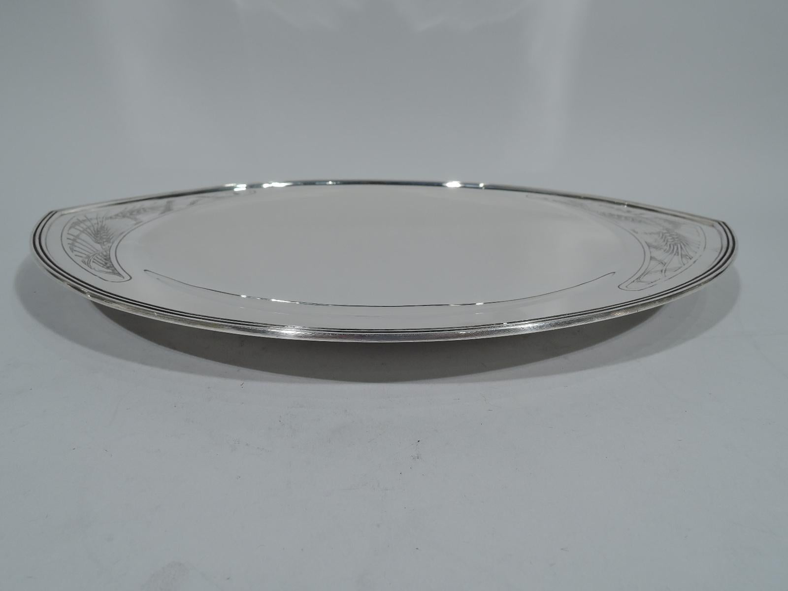 Art Deco sterling silver bread tray. Made by Tiffany & Co. in New York. Pointed oval with round shallow bowl. Ends have shaped frames with acid-etched and stylized grain heads and stalks. A stylish and wholesome addition to the dinner table.