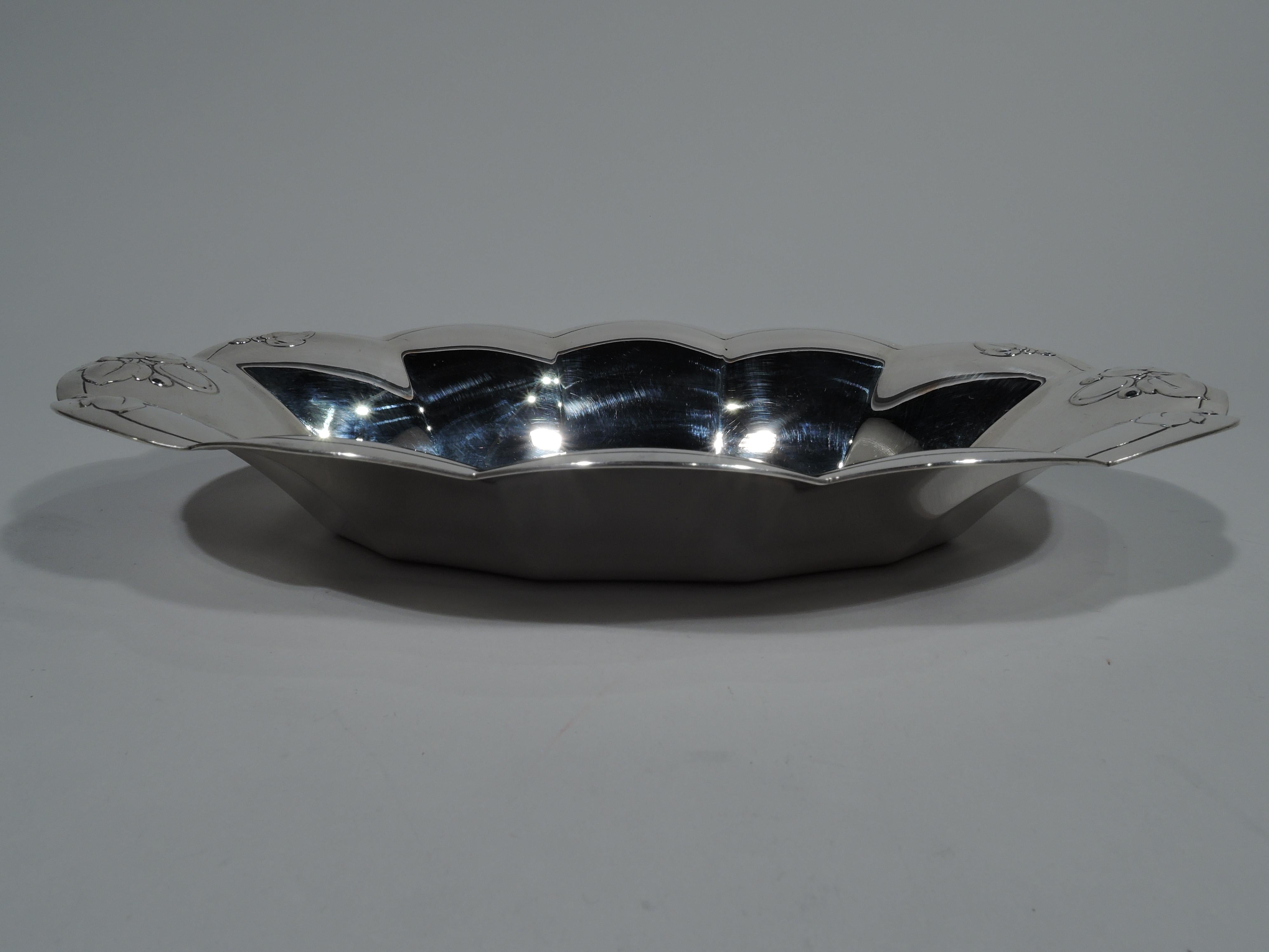 Art Deco sterling silver bread tray. Made by Tiffany & Co. in New York. Ovalish with lobed sides and petal-scalloped rim. Chased and stylized berries and leaves at ends. Hallmark includes pattern no. 22930G, director’s letter m 1907-1947, and