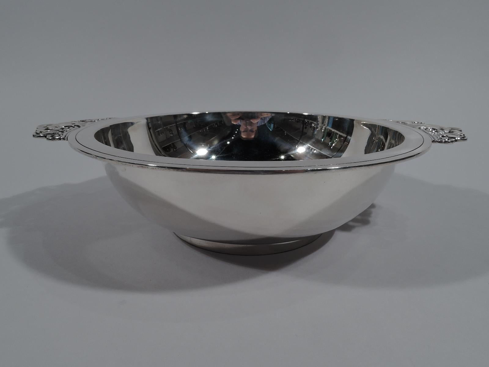 Art Deco sterling silver bowl. Made by Tiffany & Co. in New York, circa 1939. Round with flat rim and short foot ring. Mounted side handles comprising chased and pierced flowers and scrolls. Fully marked including pattern no. 22837 (first produced