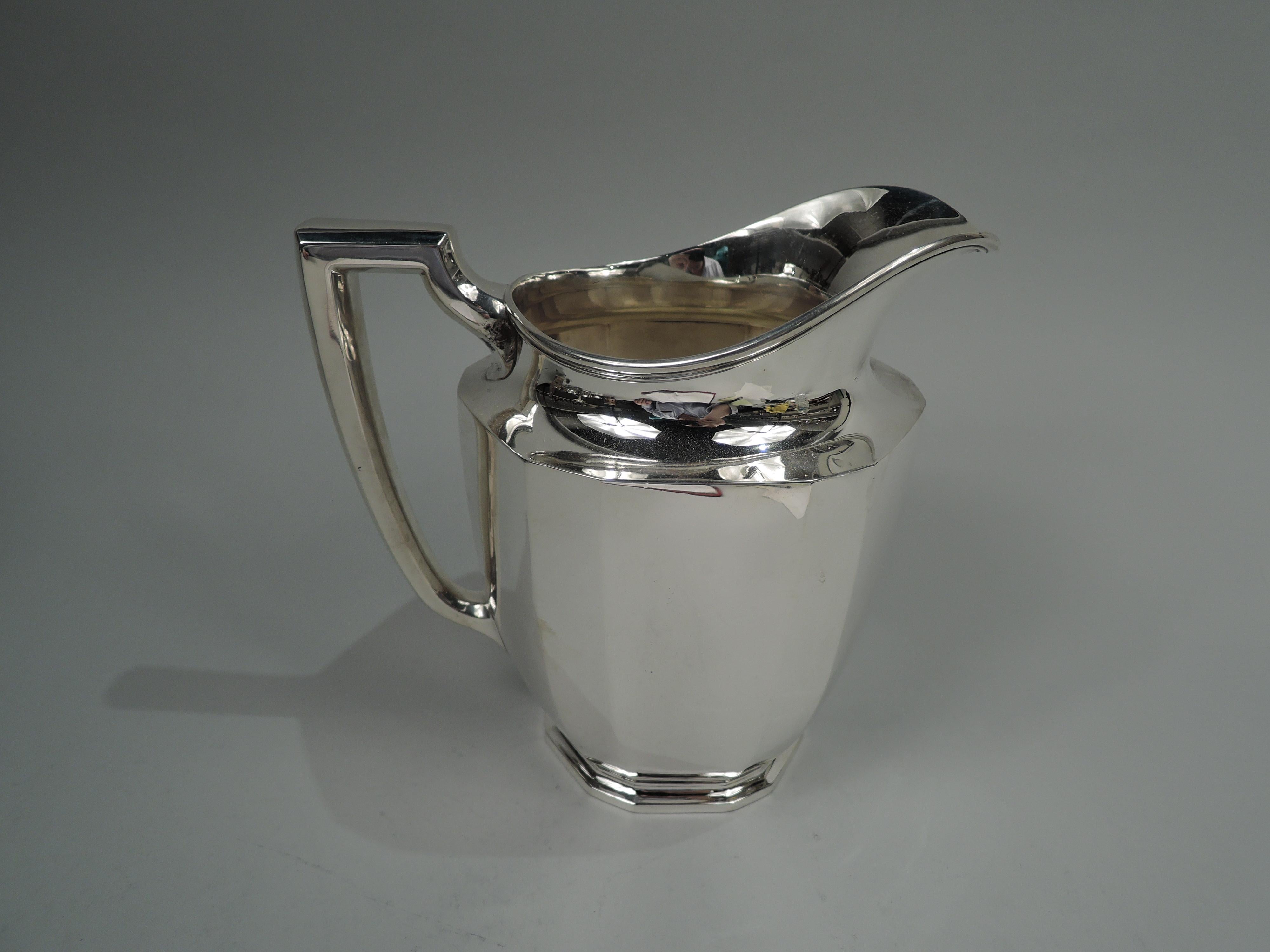 Art Deco sterling silver water pitcher. Made by Tiffany & Co. in New York, ca 1914. Curved body, stepped foot, helmet mouth, and bracket handle. Alternating wide and narrow facets on body and foot. Fully marked including maker’s stamp, pattern no.