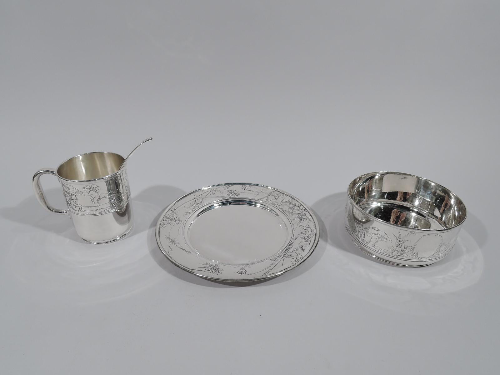 Art Nouveau sterling silver baby set. Made by Tiffany & Co. in New York, circa 1909. This set comprises cup, bowl, plate, and spoon. Acid-etched ornament in form of winged and cherubic fairies frolicking amidst giant mushrooms and aquatic grasses.