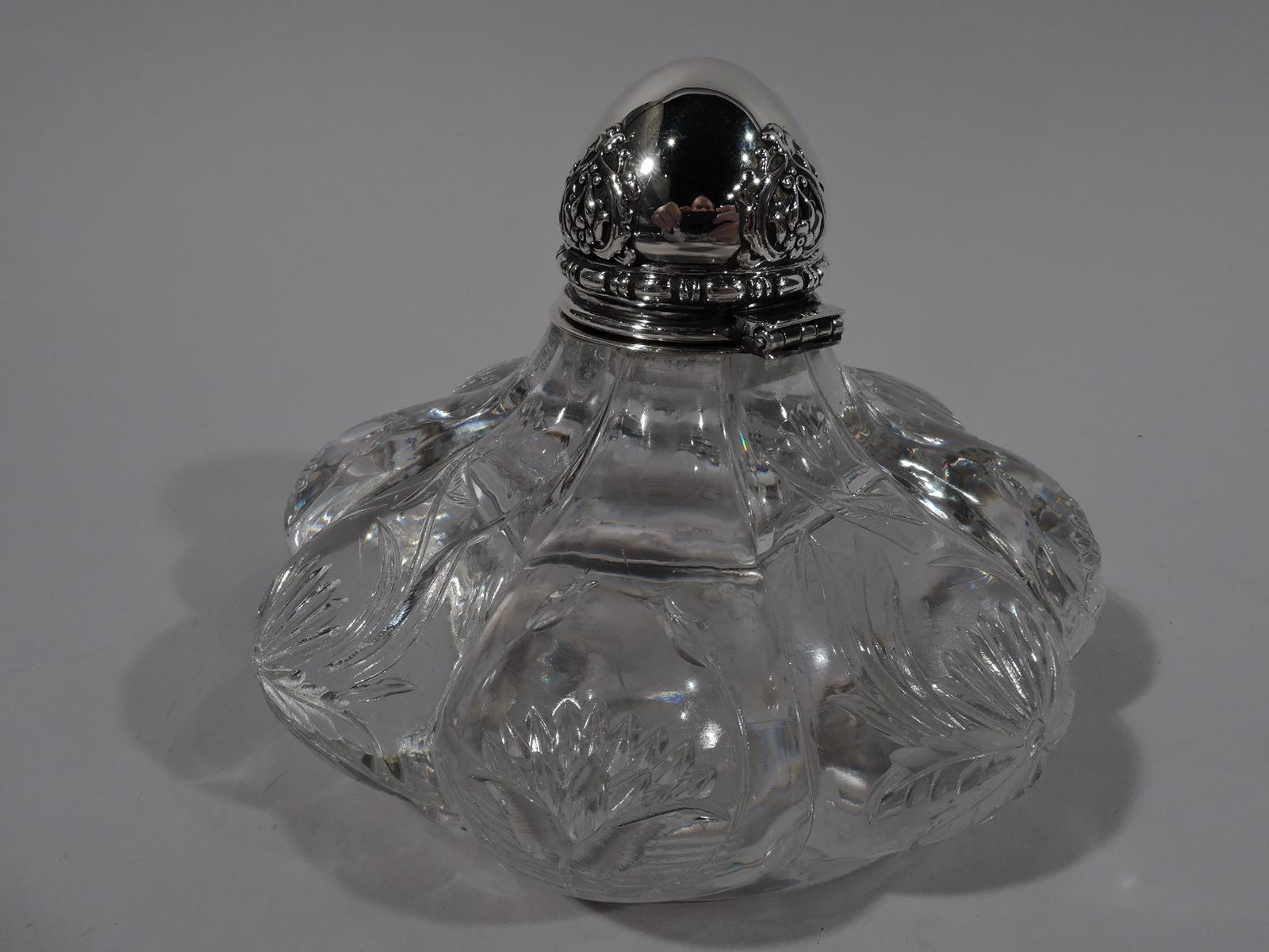 Art Nouveau sterling silver and clear glass inkwell. Made by Tiffany & Co. in New York. Bellied and lobed clear glass base with short inset foot and carved and engraved stylized flowers. Short neck with sterling silver collar and hinged ball cover