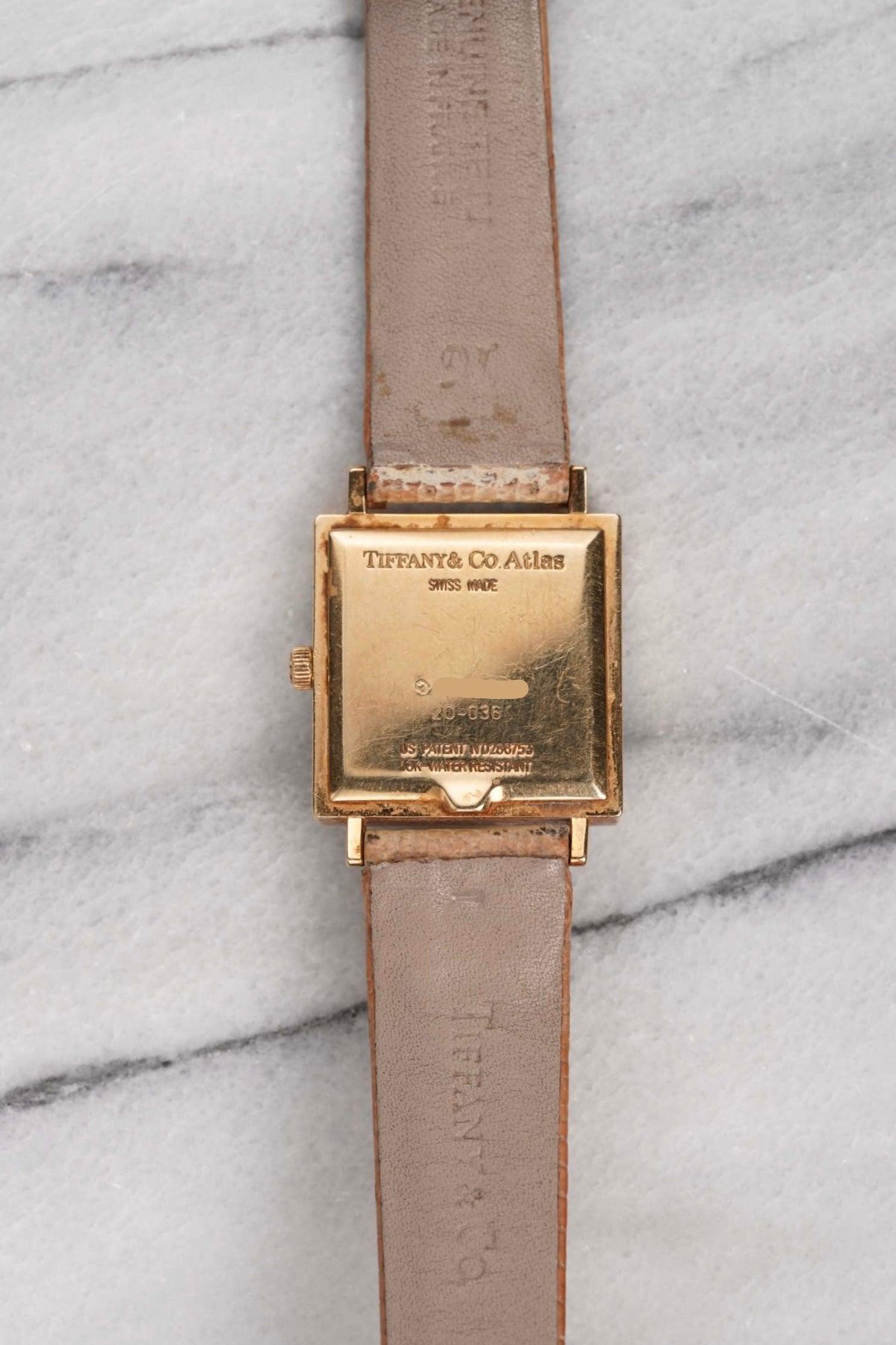 Here's a vintage Tiffany & Co in 18K yellow gold with a champagne dial quartz from the 1980s. Keeps great time and is fully functional. Measurements include a 33mm square case and 18mm lug width. On its original brown leather strap and signed