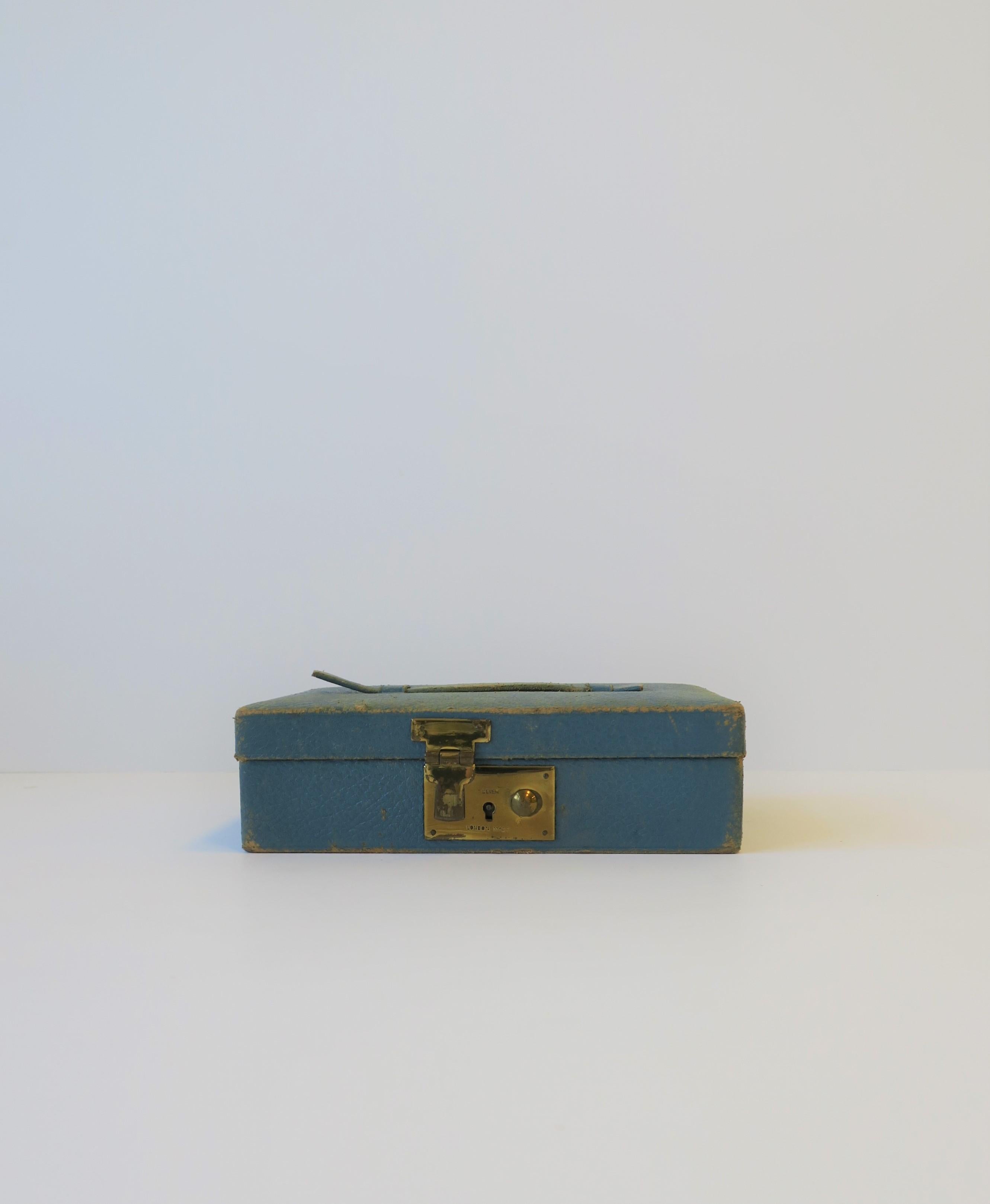 A blue leather, velvet, and brass jewelry box, made in London, circa early-20th century, England. Box is a 'Tiffany' blue leather, with a top handle, brass closure in front, and velvet lined, including a jewelry pillow. Brass closure is marked