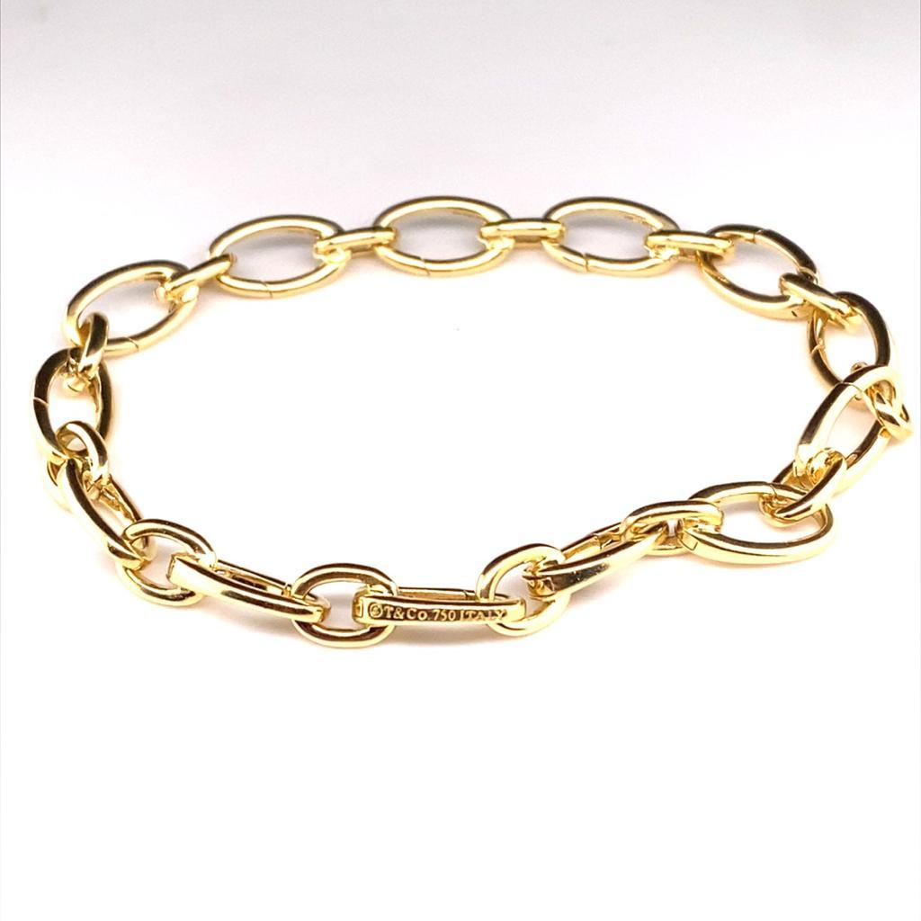 An exceptionally crafted 18 carat yellow gold charm bracelet by Tiffany & Co, circa 2010.

Composed of polished curved cable links, each individual section with its own spring loaded opening on which to easily attach a charm.

Shown here with a