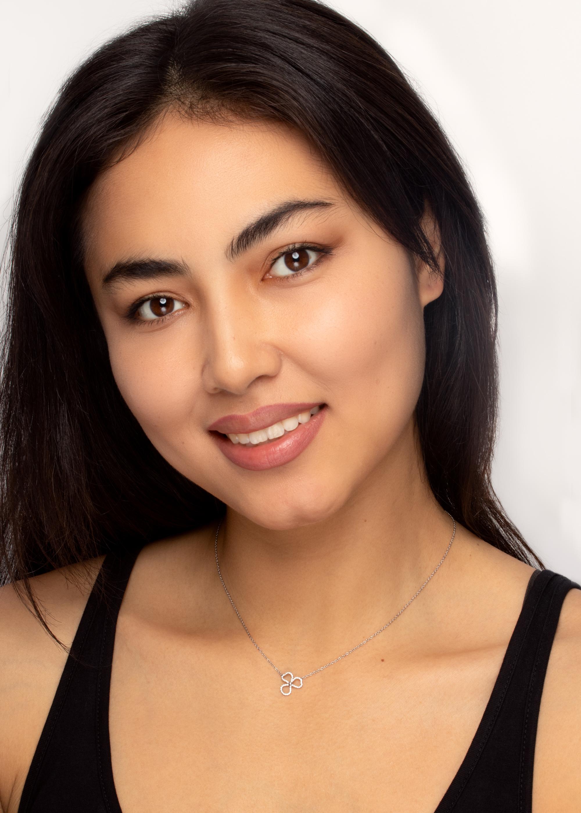 Questa deliziosa collana proviene dai designer di Tiffany & Co. Presenta un design a fiore aperto, con diamanti incastonati. Il totale di 0,12 carati di diamanti tondi brillanti ha una classificazione di colore F e di purezza VVS. Questo pezzo è