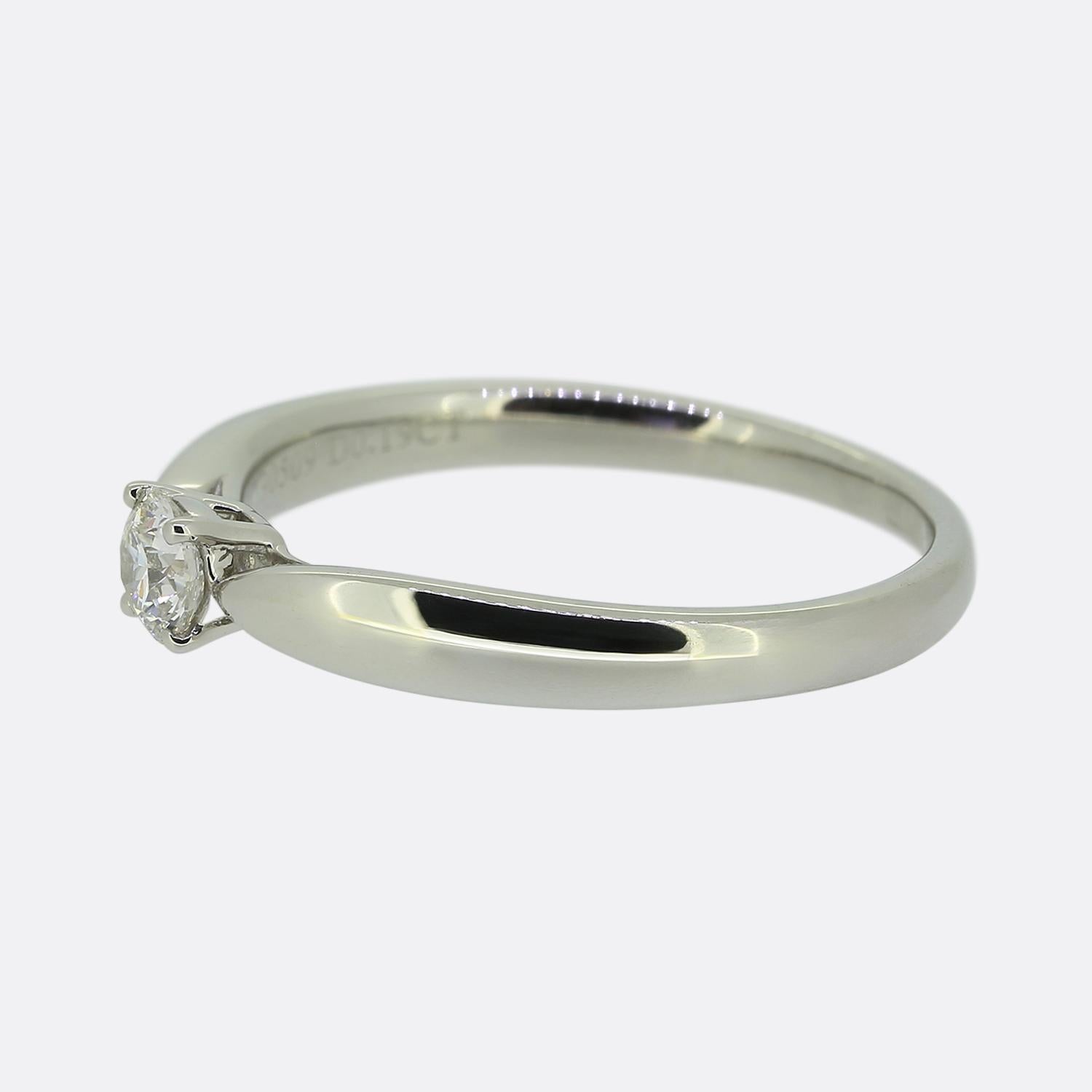 Hier haben wir einen bezaubernden Solitär-Diamantring von dem weltbekannten Schmuckdesigner Tiffany & Co. Dieses elegante Schmuckstück ist aus Platin gefertigt und mit einem einzelnen runden Brillanten in der Mitte der Vorderseite versehen. Der