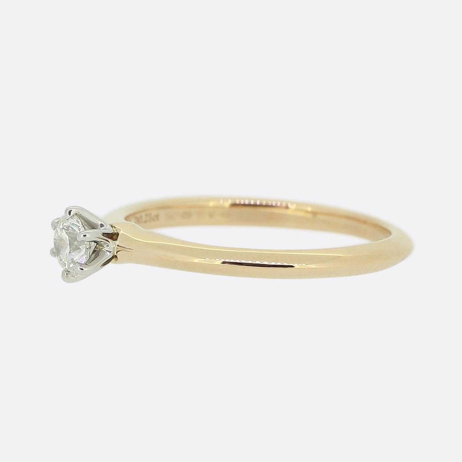 Hier haben wir einen klassischen Diamant-Verlobungsring des weltbekannten Schmuckdesigners Tiffany & Co. Ein einzelner runder Diamant im Brillantschliff von 0,21 Karat sitzt in einer 6-Krallen-Fassung aus Platin auf dem ikonischen Messerband von