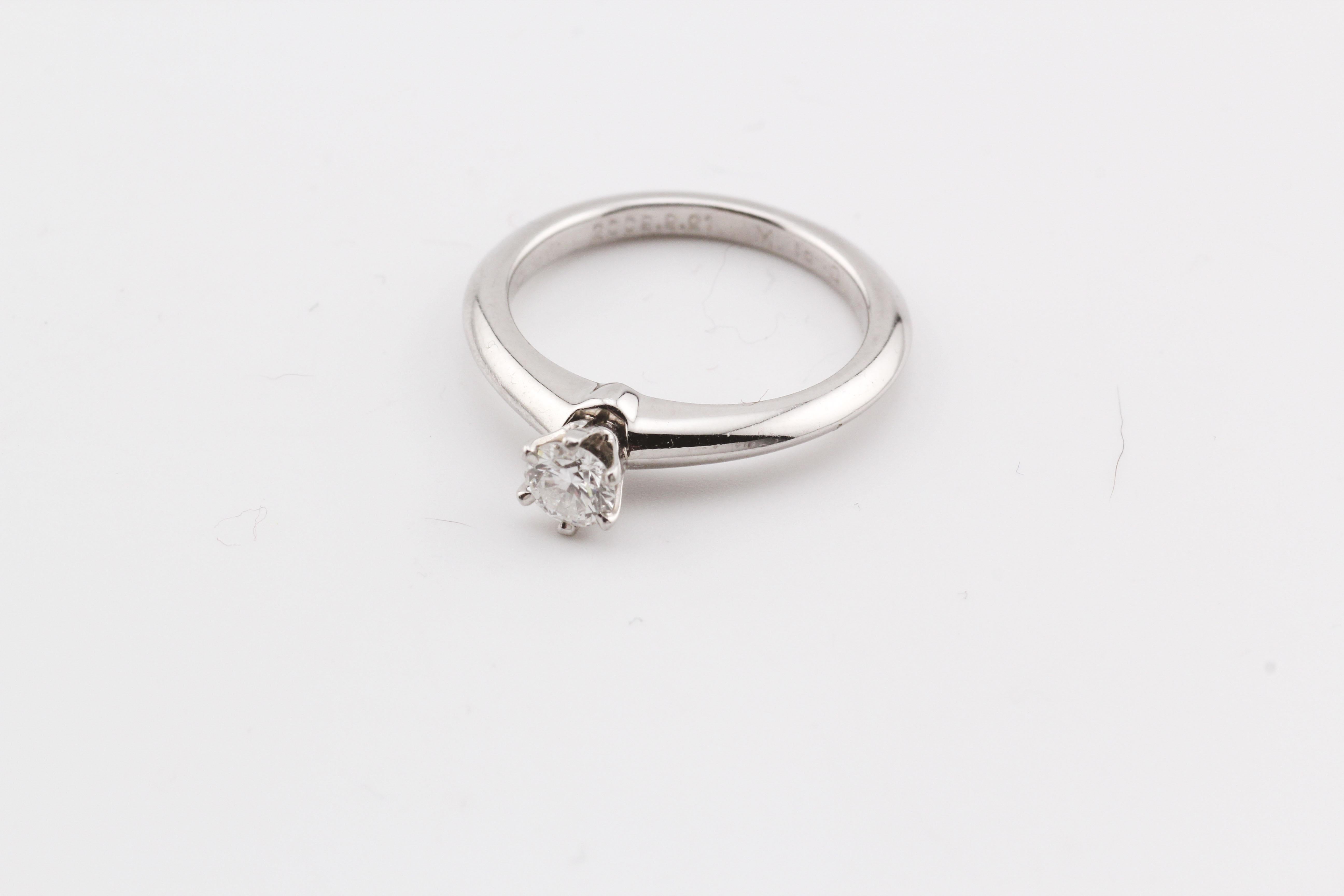 Introducing the Tiffany & Co. Diamond Solitaire Engagement Ring—a testament to timeless elegance and refined craftsmanship. This exquisite piece by Tiffany & Co. showcases a brilliant white diamond, meticulously set to capture and reflect light with