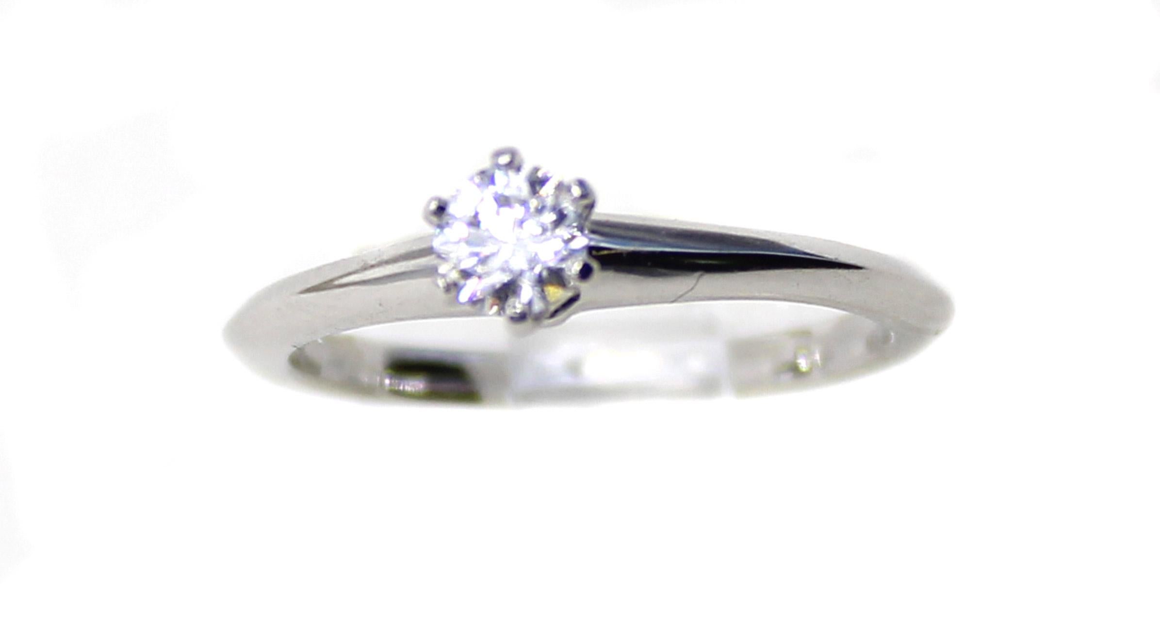 Platinum handcrafted ring by Tiffany & Co. featuring a perfect round brilliant cut diamond secured by 6 prongs. The central diamond is accompanied by a Tiffany certificate stating that the color is E and the clarity  VVS2. Signed on the inside of