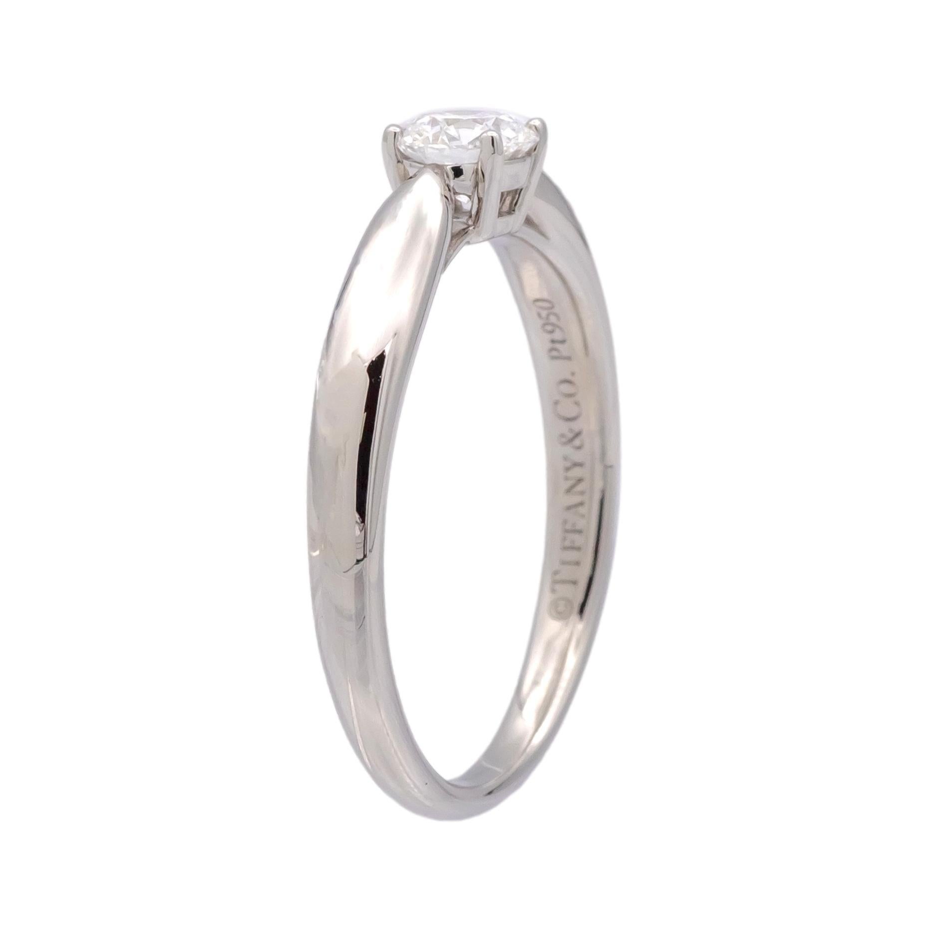 This Tiffany & Co. Harmony Collection ring is finely crafted in platinum and features a 0.26-carat round brilliant-cut diamond. Graded E color and VS1 clarity, the diamond is rated Excellent for cut, Polish, and Symmetry, enhancing its brilliance