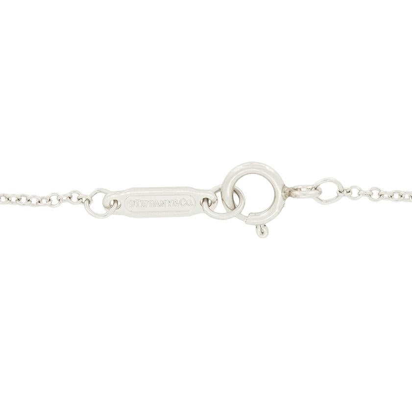Da Tiffany & Co. arriva questo bellissimo ciondolo della collezione Soleste. Uno smeraldo verde intenso si trova al centro del pezzo, circondato da un'aureola di diamanti tondi brillanti. Lo smeraldo taglio rotondo pesa 0,30 carati ed è incastonato