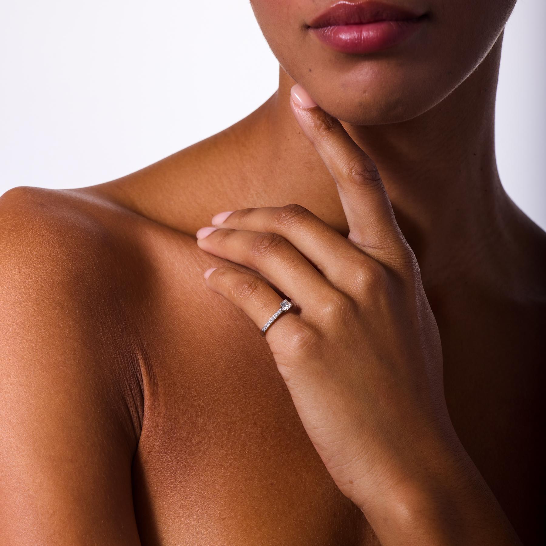 Raffinée et rayonnante, cette bague de fiançailles moderne de Tiffany & Co. capture l'essence du savoir-faire légendaire de la maison et de son design intemporel. Un éblouissant diamant de taille coussin scintille au centre, encadré par un ensemble