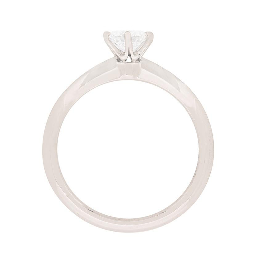 
Cette bague de fiançailles classique de Tiffany & Co est ornée d'un diamant rond brillant de 0,45 carat. Il s'agit d'une pierre étincelante, estimée de couleur G et de pureté VS1. Le diamant est serti de manière experte dans un collier à 6 griffes