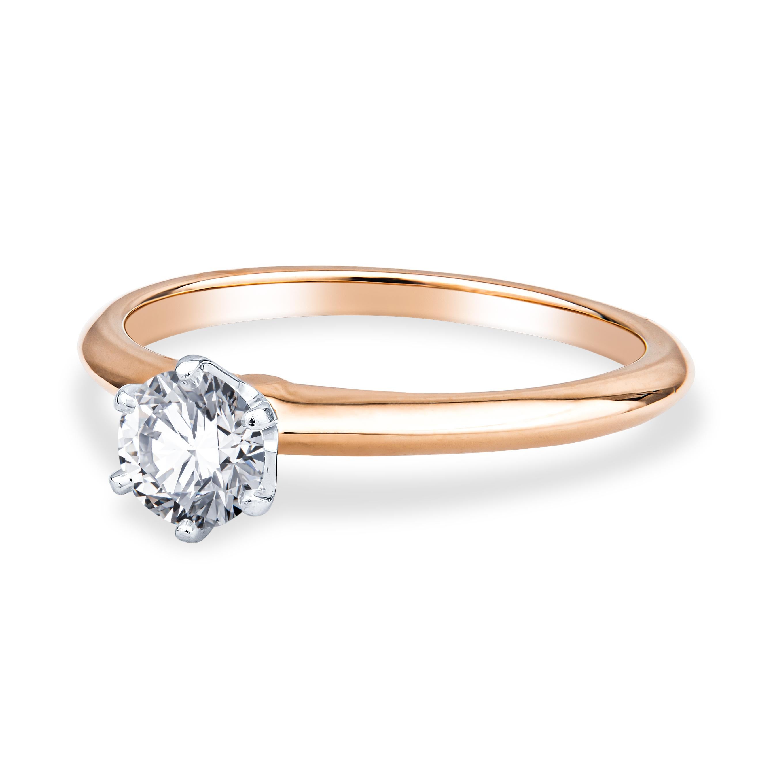 This precious Tiffany & Co. engagement ring features a dainty 0.57ct round brilliant cut diamond, I VS1. The diamond is placed in a platinum setting and an 18kt rose gold engagement ring. The ring has a Tiffany Report (#673950). It is currently a
