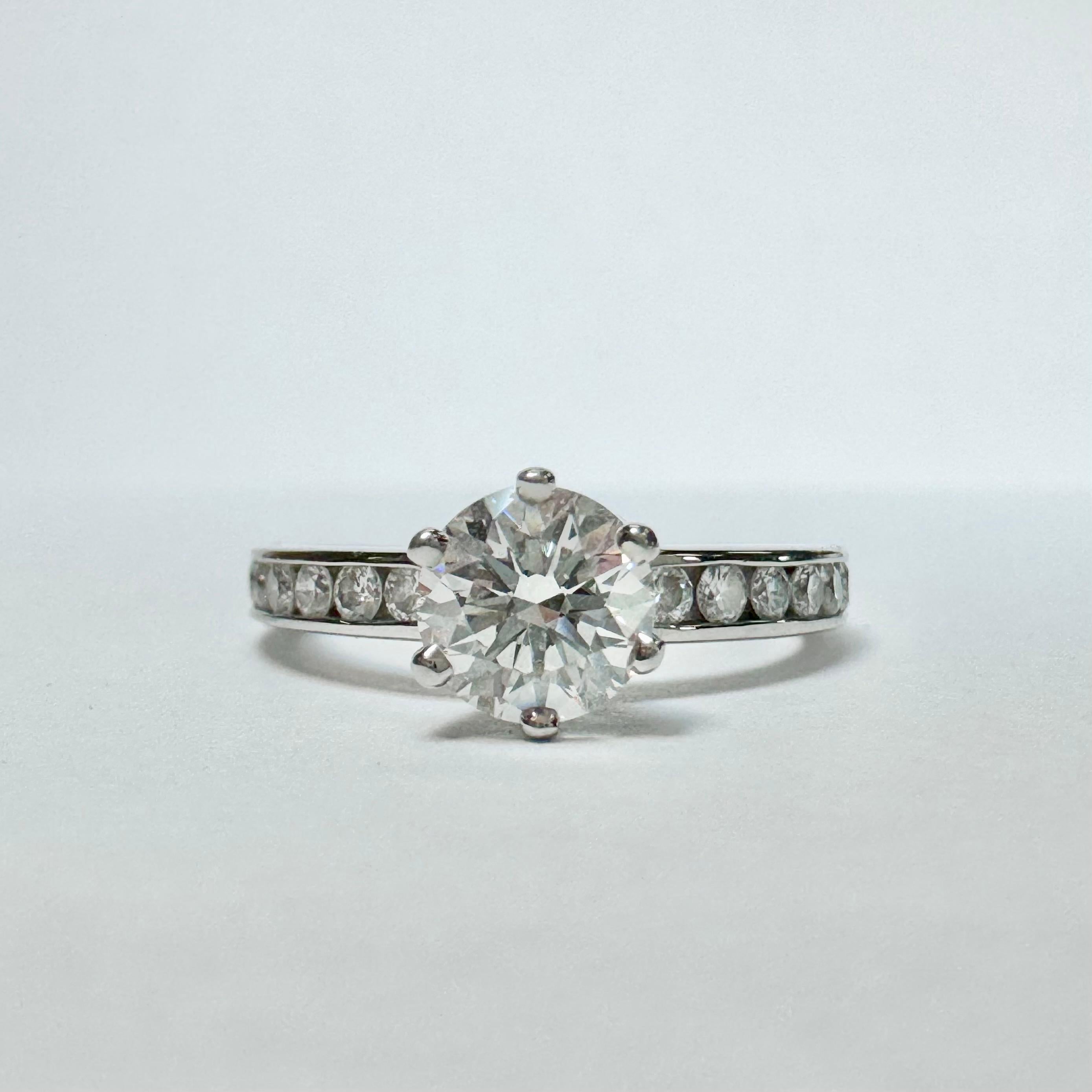 Tiffany & Co. La bague de fiançailles en diamant a une pierre centrale de 0,64ct, avec des diamants d'accentuation sertis en canal dans un anneau en platine massif. Le diamant rond central de taille brillant pèse 0,64ct, a une taille de  Couleur F