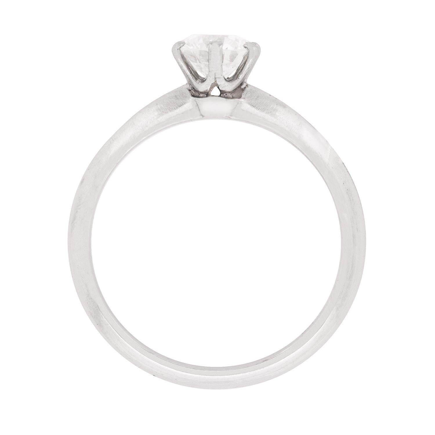 Set within a six claw setting, this stunning Tiffany & Co solitaire ring is classic in every way. It holds a high quality and dazzling diamond. Certified by Tiffany & Co as VS1 in clarity and F in colour, the setting allows the light to reach all