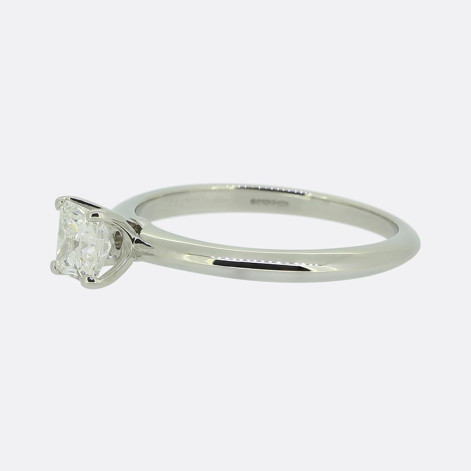 Here we have a diamond solitaire engagement ring from the world renowned jewellery designer, Tiffany & Co. At the centre of the face we find a 0.66 carat princess cut diamond which sits alone proud in a four-clawed setting atop Tiffany's iconic