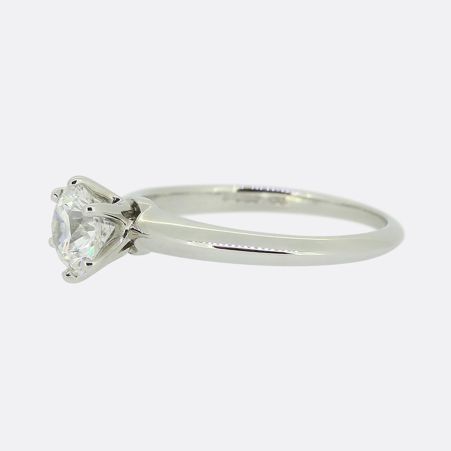 Hier haben wir einen wunderschönen Solitär-Verlobungsring aus Platin von dem weltbekannten Schmuckdesigner Tiffany & Co. Der Mittelstein ist ein beeindruckender runder Brillant von 1,01 Karat, gefasst in Tiffanys ikonischer