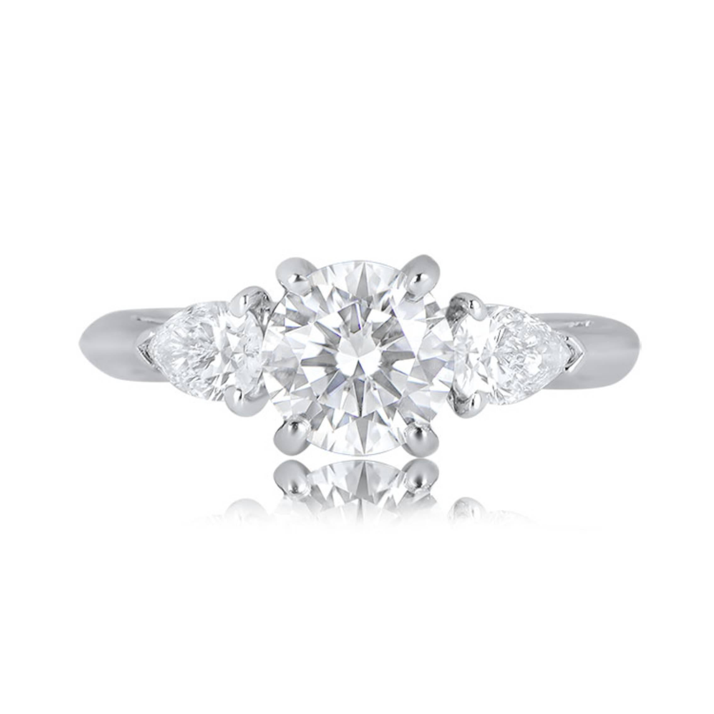 A captivating Tiffany engagement ring showcasing a brilliant 1.04-carat diamond with G color and VS1 clarity. Complementing the center stone are two pear-shaped diamonds, totaling 0.47 carats, also in G color and VS1 clarity. Crafted in platinum,