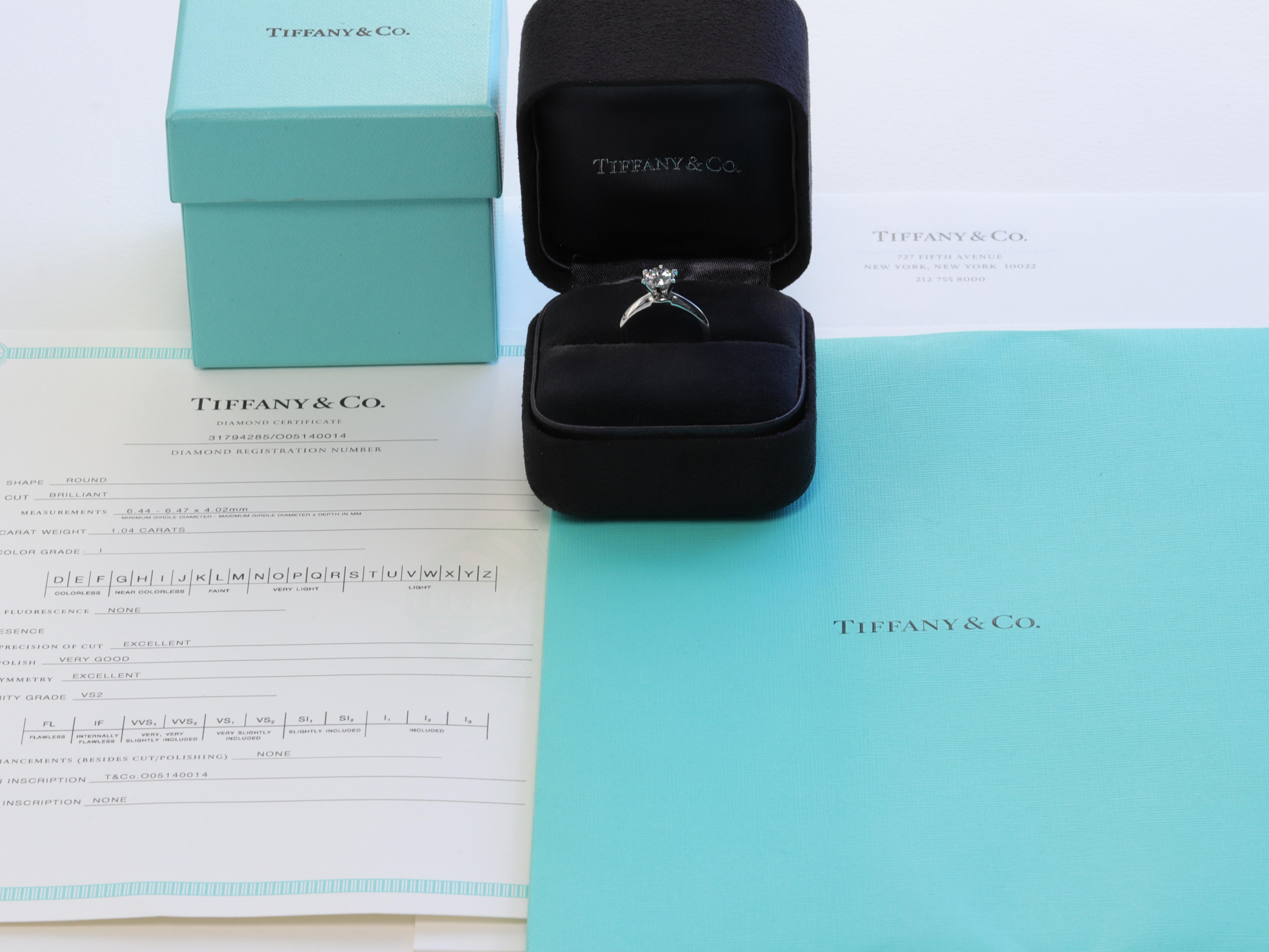 The ring is accompanied by the original inside and outside boxes, original diamond certificate and valuation report from Tiffany & Co. 

This classic Tiffany & Co. solitaire diamond engagement ring features a 1.04 carat round brilliant cut diamond