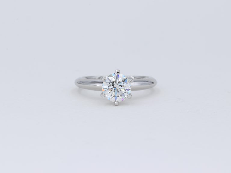 This classic Tiffany & Co. solitaire diamond engagement ring features a 1.04 carat round brilliant cut diamond graded I in color and VS2 clarity by Tiffany & Co. 

The ring is accompanied by the original inside and outside boxes, original diamond