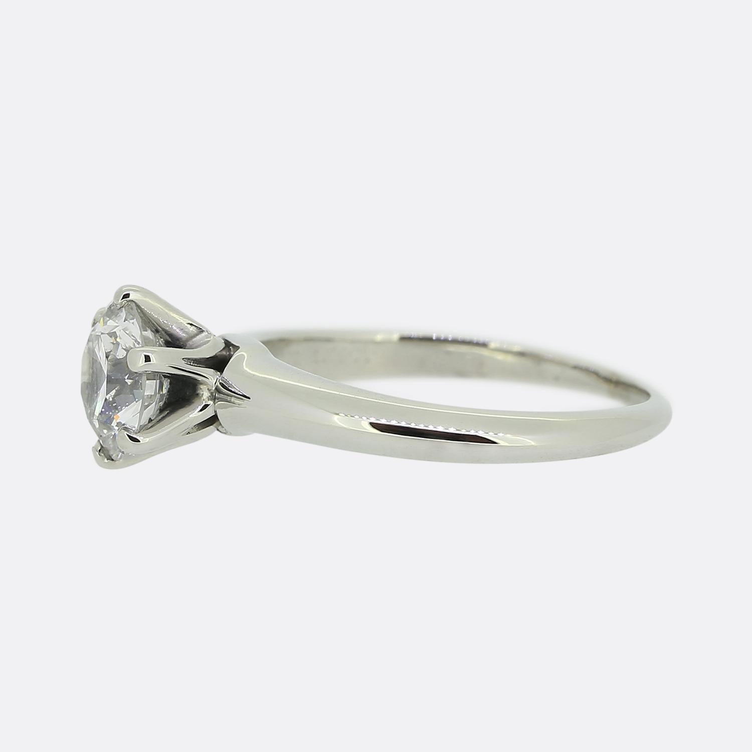 Nous avons ici une magnifique bague de fiançailles solitaire du créateur de bijoux de renommée mondiale, Tiffany & Co. La pierre centrale est un superbe diamant rond de 1,01 carat taillé en brillant, serti dans une monture emblématique de Tiffany à