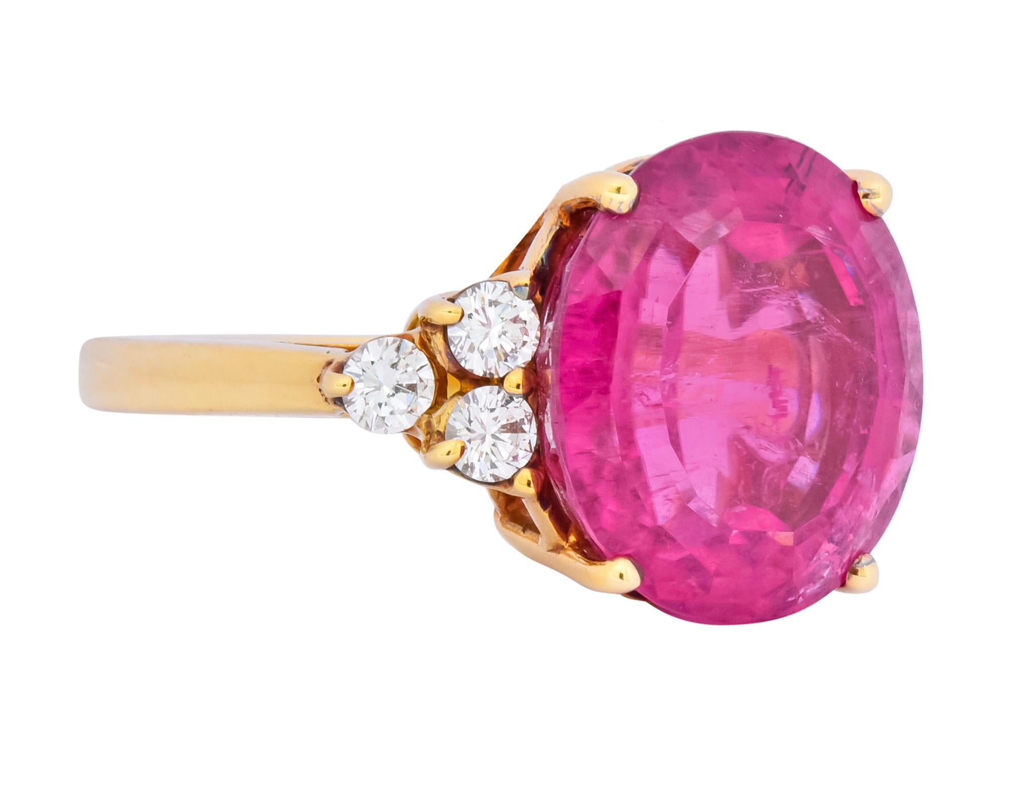Centering a basket set set oval mixed cut tourmaline weighing approximately 10.73 carat, transparent and a saturated hot pink color

Flanked by round brilliant cut diamonds, prong set in triangular formations, weighing approximately 0.36 carat, G/H
