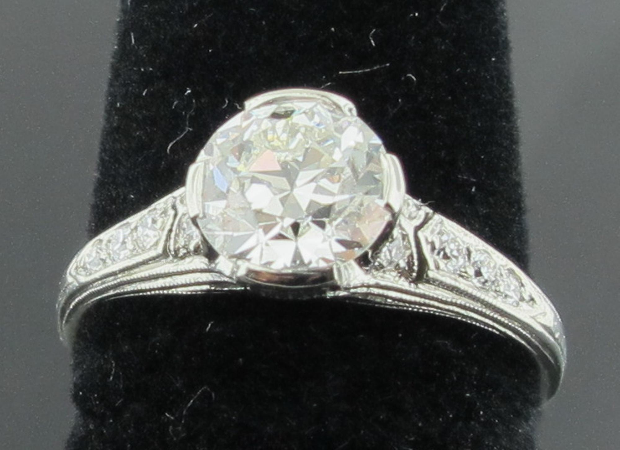 Vintage Tiffany & Co. Platinum ring with a Transitional Cut center diamond weighing 1.20 carats, Color G-H, Clarity VS.  Ring includes 10 round brilliant cut diamonds of the same period, weighing 0.10 carats.  Set in Platinum.  Ring size is 6.
