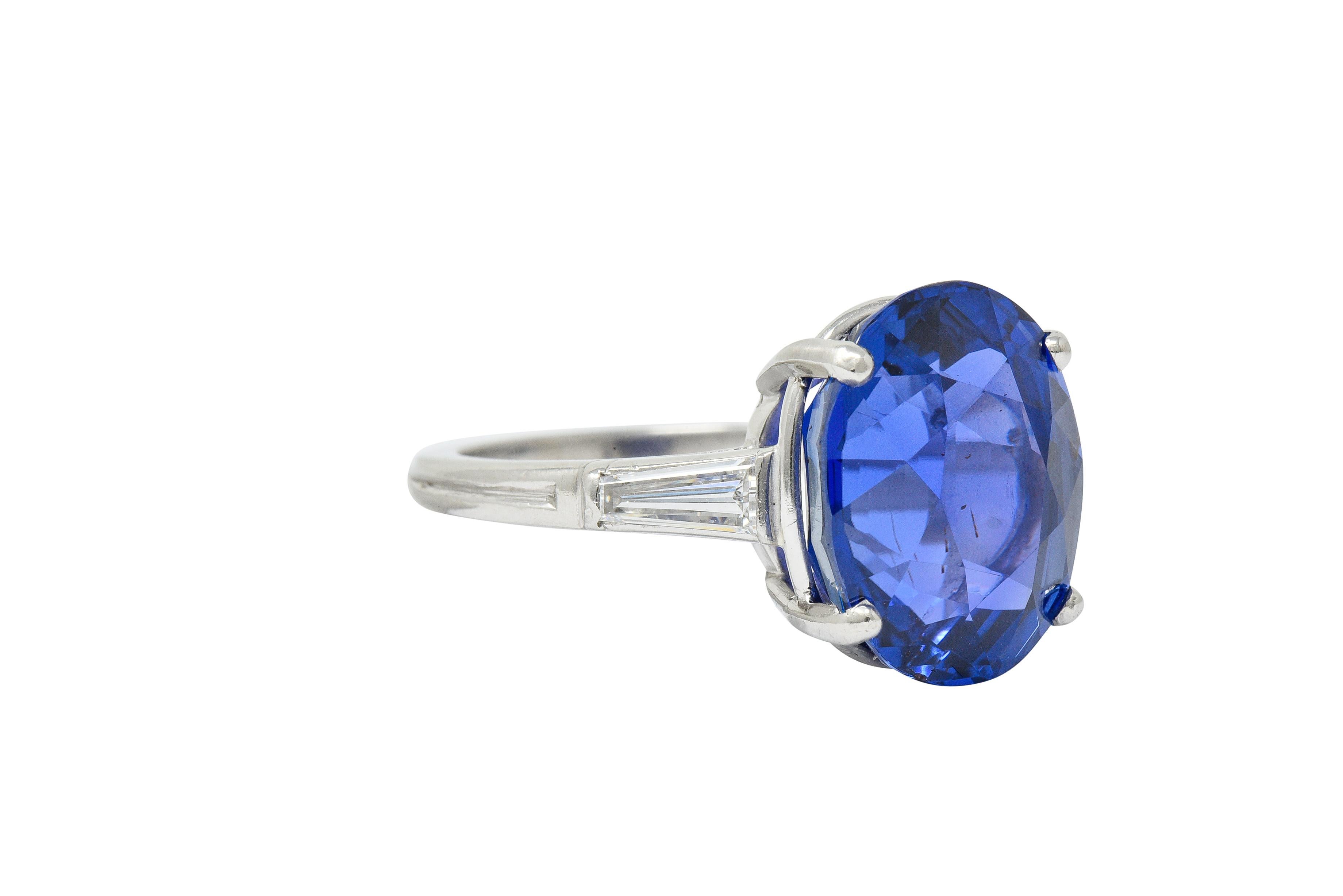 Kathedrale Korb Ring zentriert einen ovalen Schliff Ceylon Saphir mit einem Gewicht von 11,83 Karat

Transparent und intensiv violett-blau in der Farbe ohne Anzeichen von Hitze; aus Sri Lanka stammend

Flankiert von zwei spitz zulaufenden Diamanten