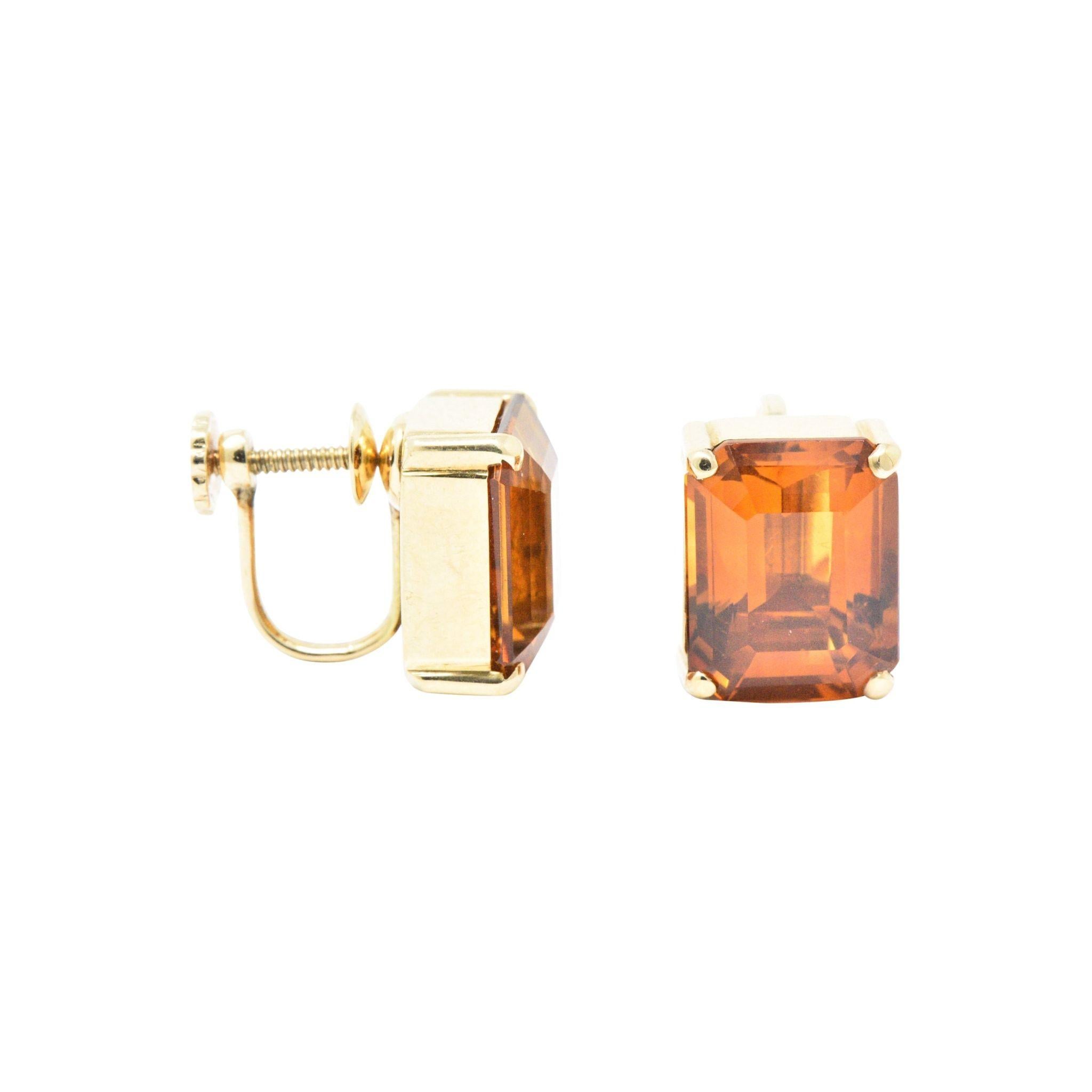 Each centering a rectangular step cut citrine, 12.25 carats total, with a rich orange color, very well matched
In a clean four prong with polished gold bezel mounting
Screw backs
Signed Tiffany & Co. 
Total Weight: 7. Grams
Retro. Tiffany. Clean. 
