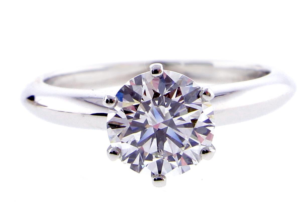From Tiffany & Co. a round brilliant diamond engagement ring.  The diamond weighs 1.29 carat, H color and VS1 clarity. The ring is in as new condition. 
♦ Designer / Hallmarks: Tiffany & Co
♦ Metal: Platinum  
♦ Gem stone: Diamonds = 1.29 Carats