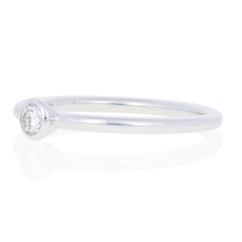 Tiffany. The name says it all! Designed by Tiffany & Co. in high purity 18k white gold, this lovely Bezet ring showcases a natural diamond. The round cut diamond is bezel-set in gleaming white gold and ported from the sides for enhanced brilliance