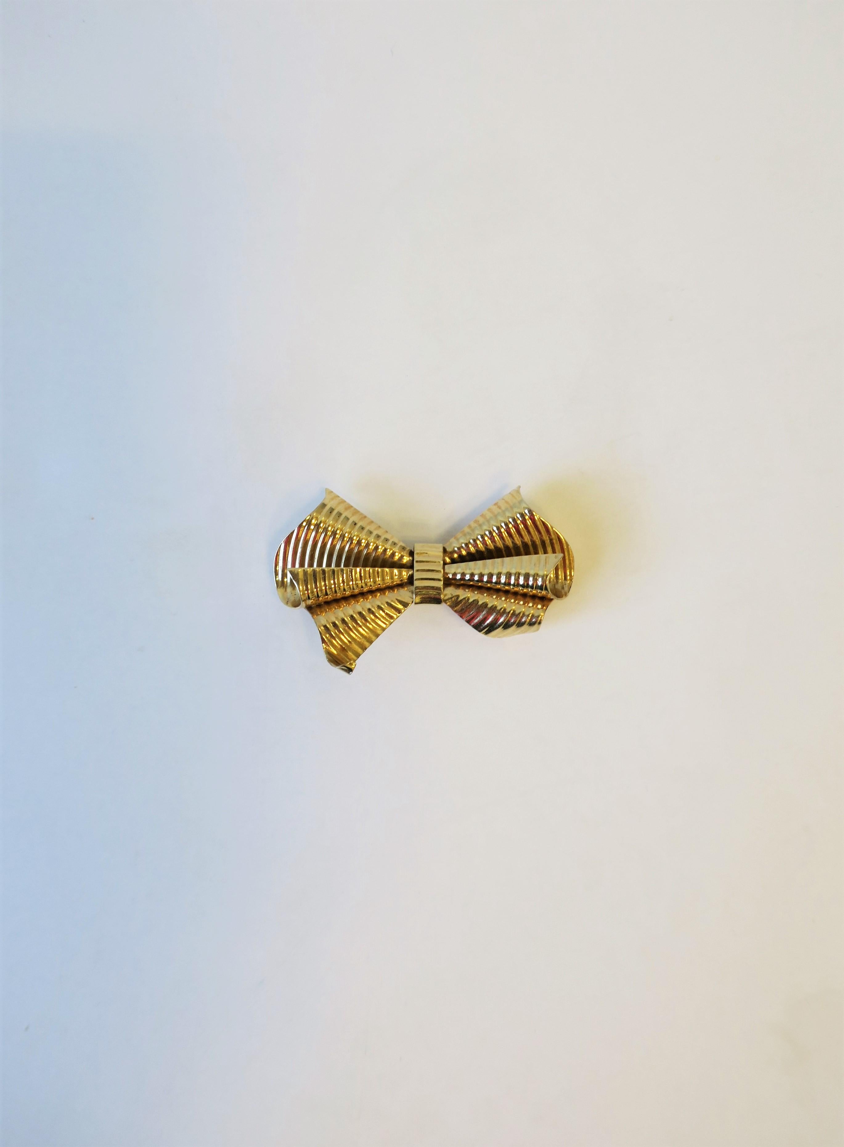 A very beautiful 14-karat yellow gold bow pin brooch from luxury jeweler Tiffany & Co., New York. Brooch is marked '14kt' on back center as show in image #10. Brooch is also marked 'Tiffany' on pin bar on back as shown in last image. Very good