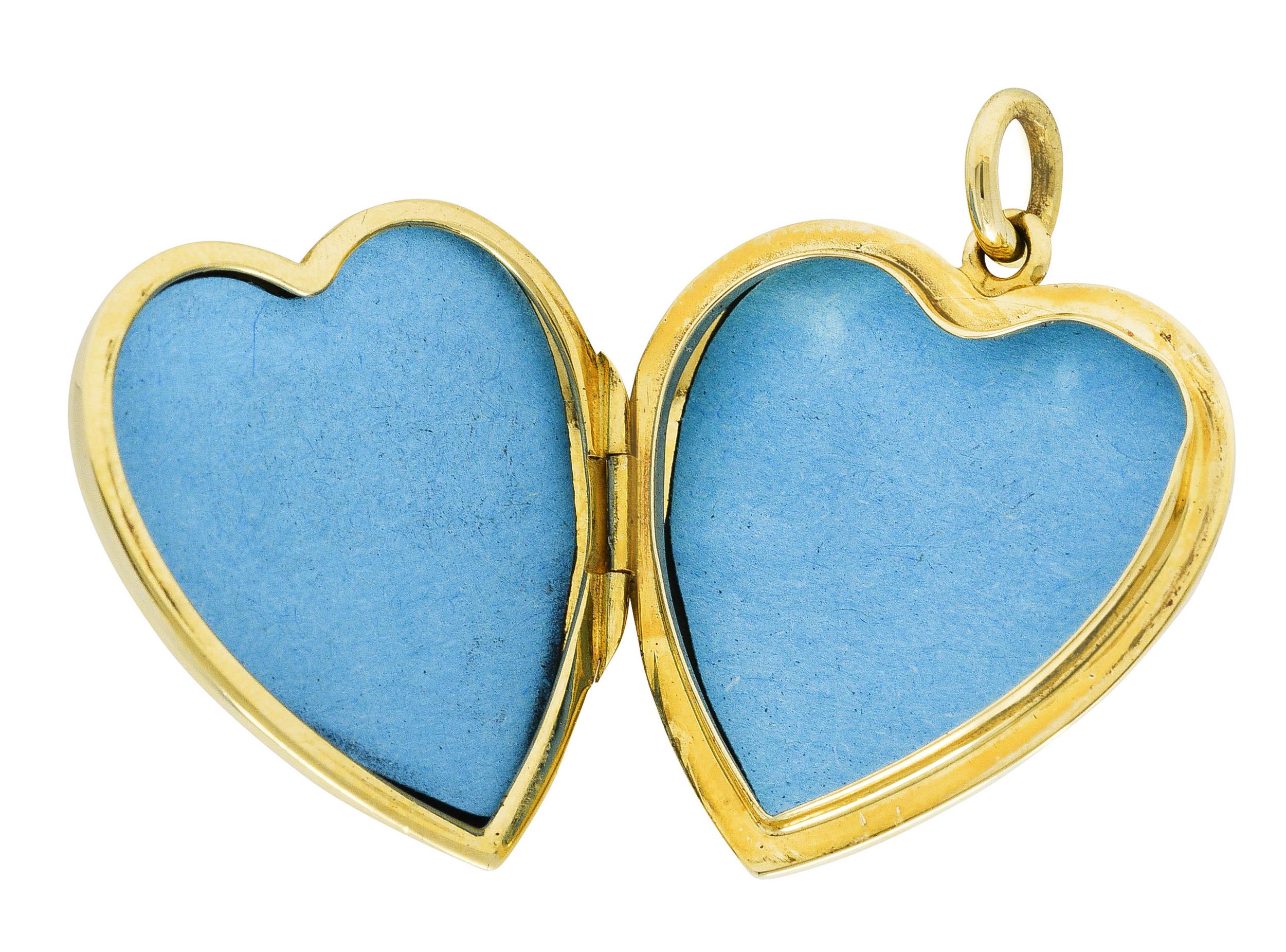 Pendant is designed as a puffed high polished gold heart. Opens on a hinge to reveal two heart shaped recesses with blue paper lining. Completed by jump ring bale. Stamped 585 for 18 karat gold. Fully signed Tiffany & Co. Italy. Circa: 1960's.