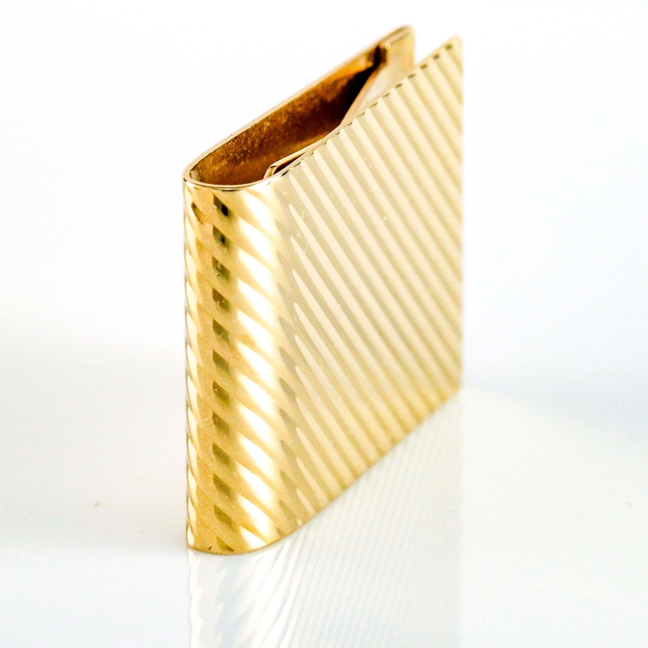 Tiffany and Co. wide money clip in 14 karat yellow gold with groove pattern. Smooth polished metal back.